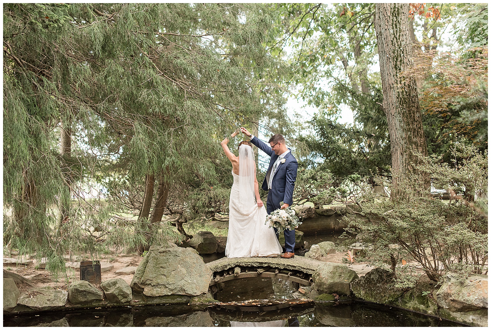 groom twirling bride under his right arm as they stand on large rocks at lauxmont farms