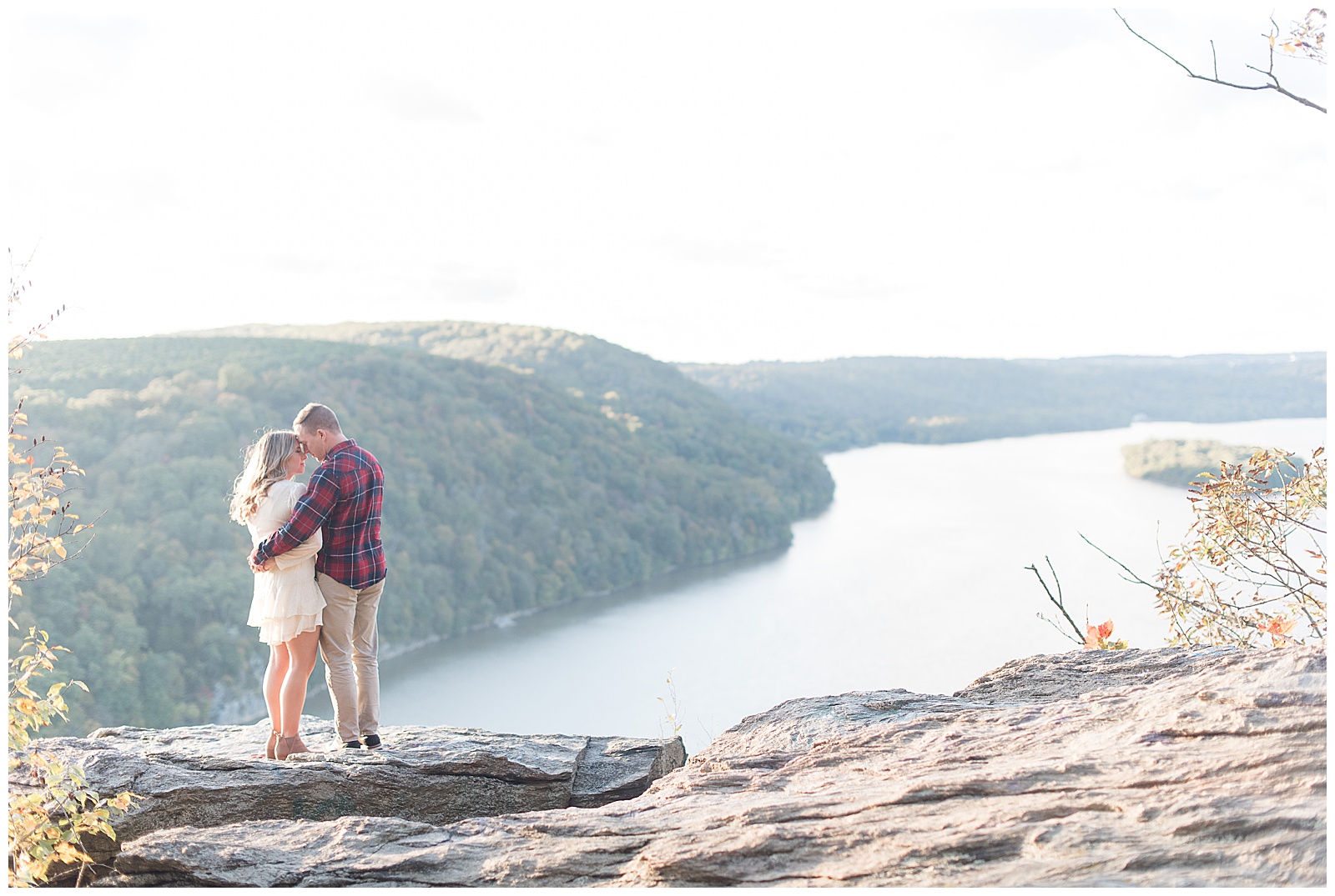couple standing on rock with guy wrapped his arms around girl's back on sunny fall day atop pinnacle overlook by susquehanna river