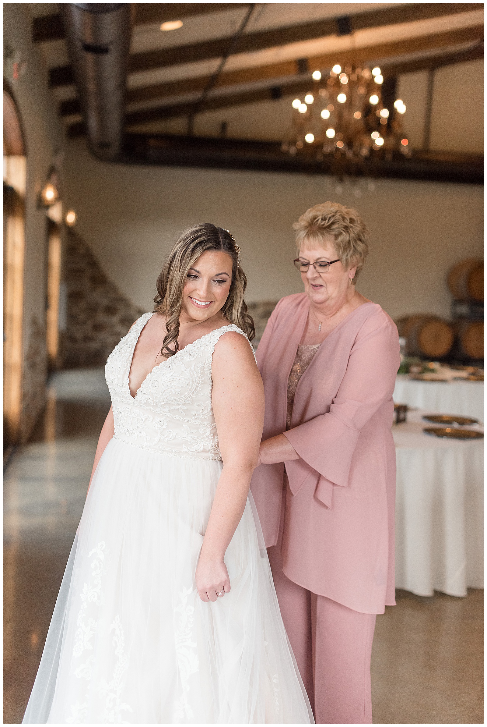 bride wearing sleeveless v-nick wedding gown with her mother wearing mauve pink outfit at folino estate