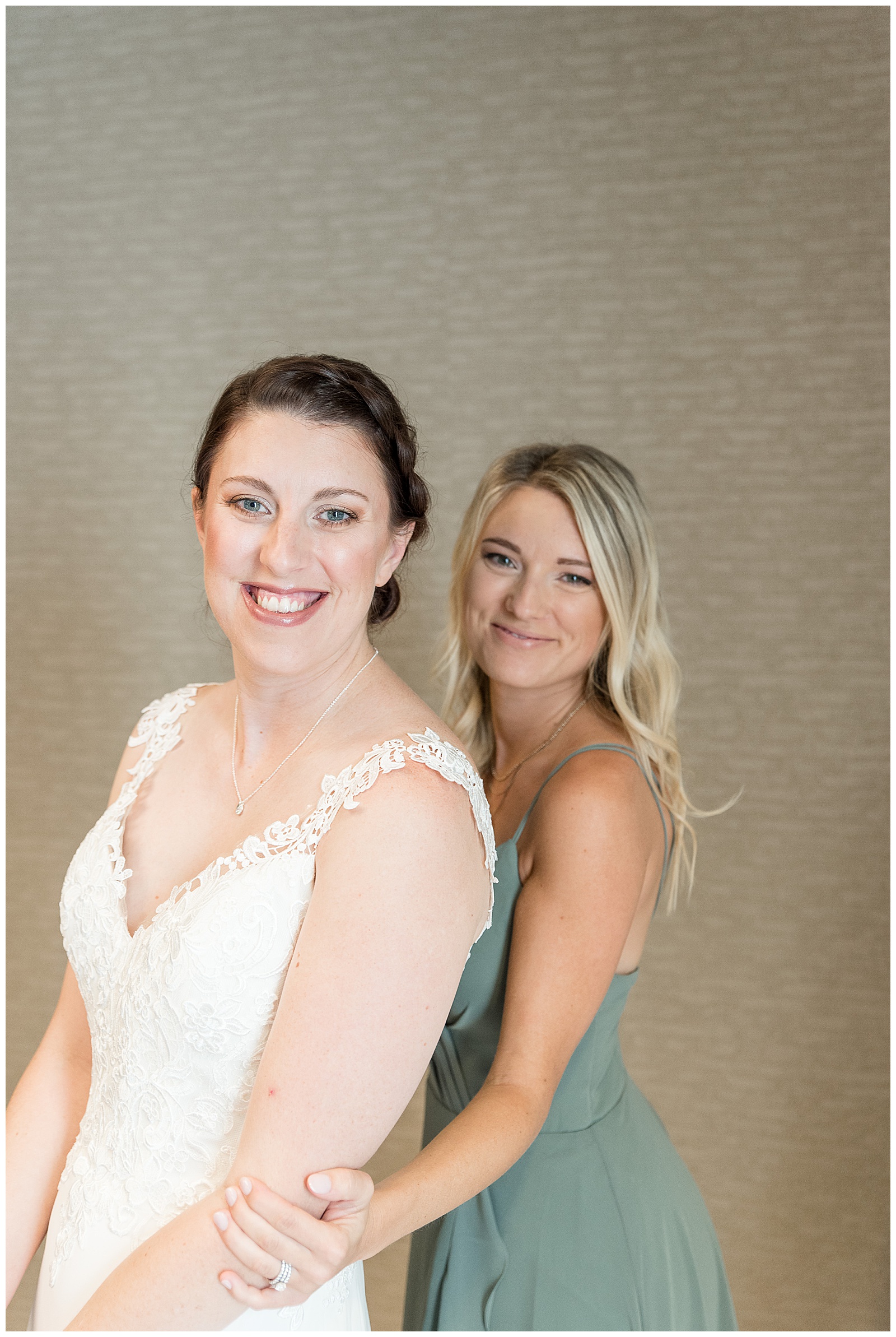 bride in white wedding gown with her maid of honor in muted green sleeveless gown in collegeville pennsylvania