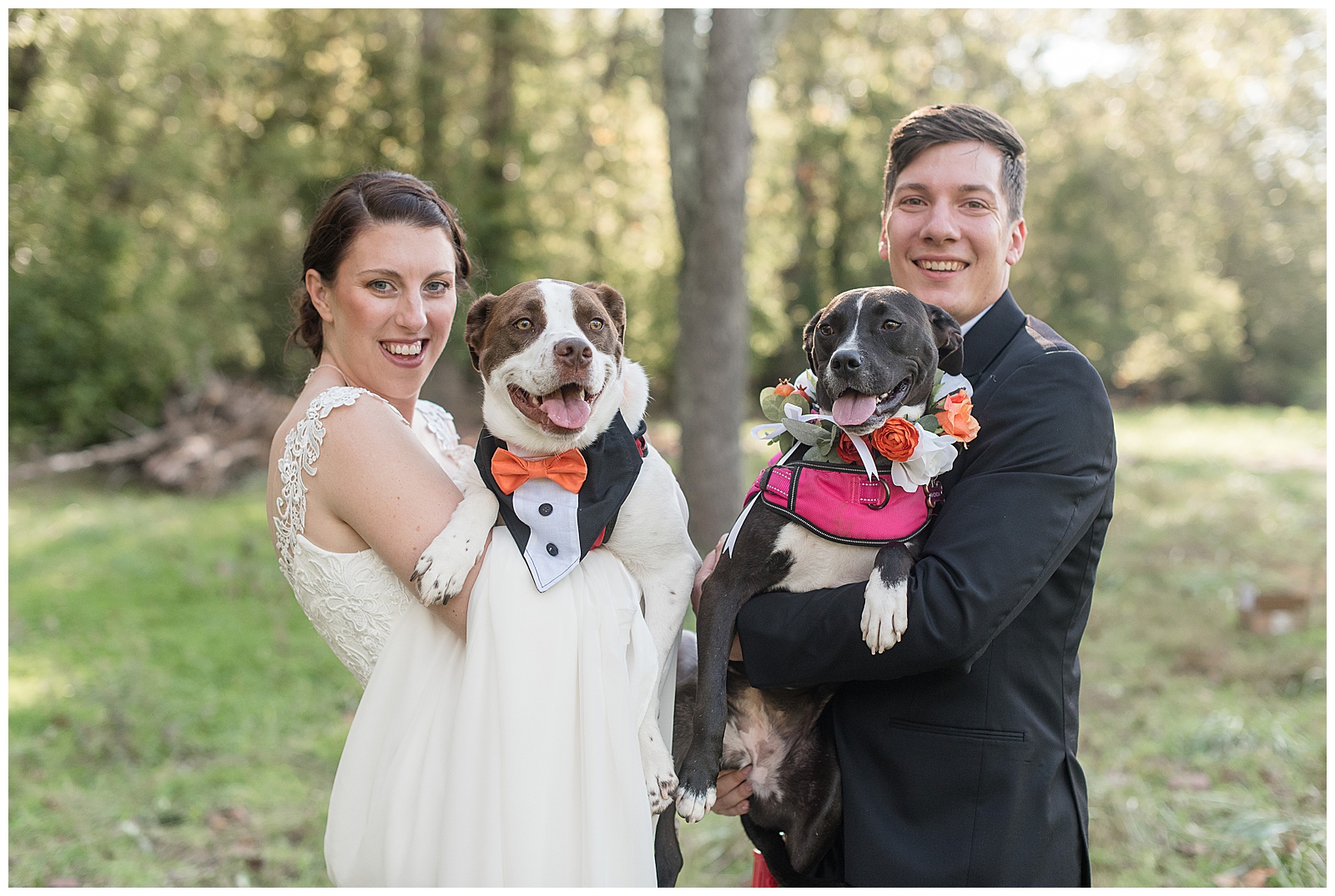 bride and groom each holding one of their dogs as everyone is looking at the camera and smiling in collegeville pennsylvania