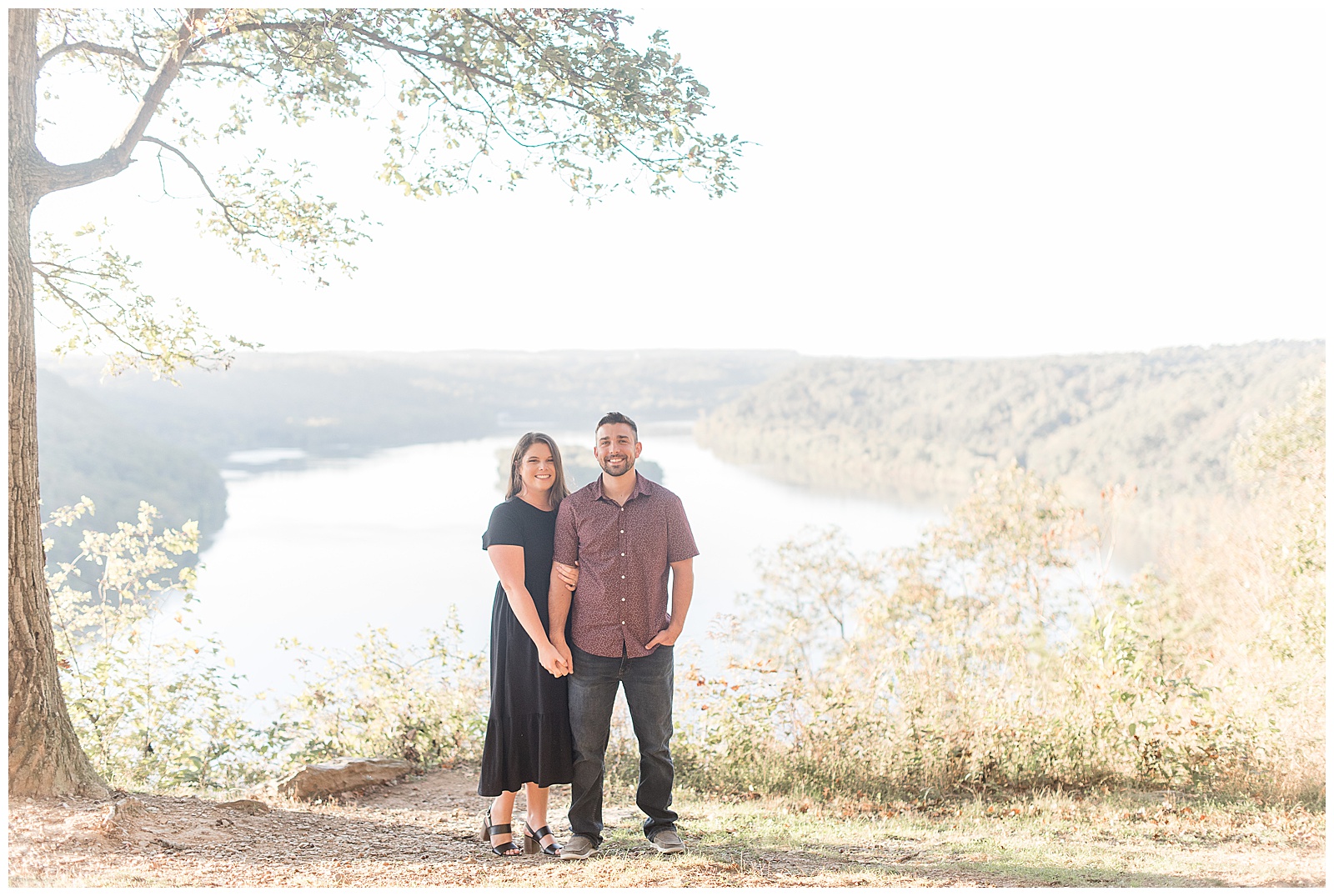 engaged couple holding hands smiling at camera with susquehanna river behind them at pinnacle point overlook in lancaster pennsylvania