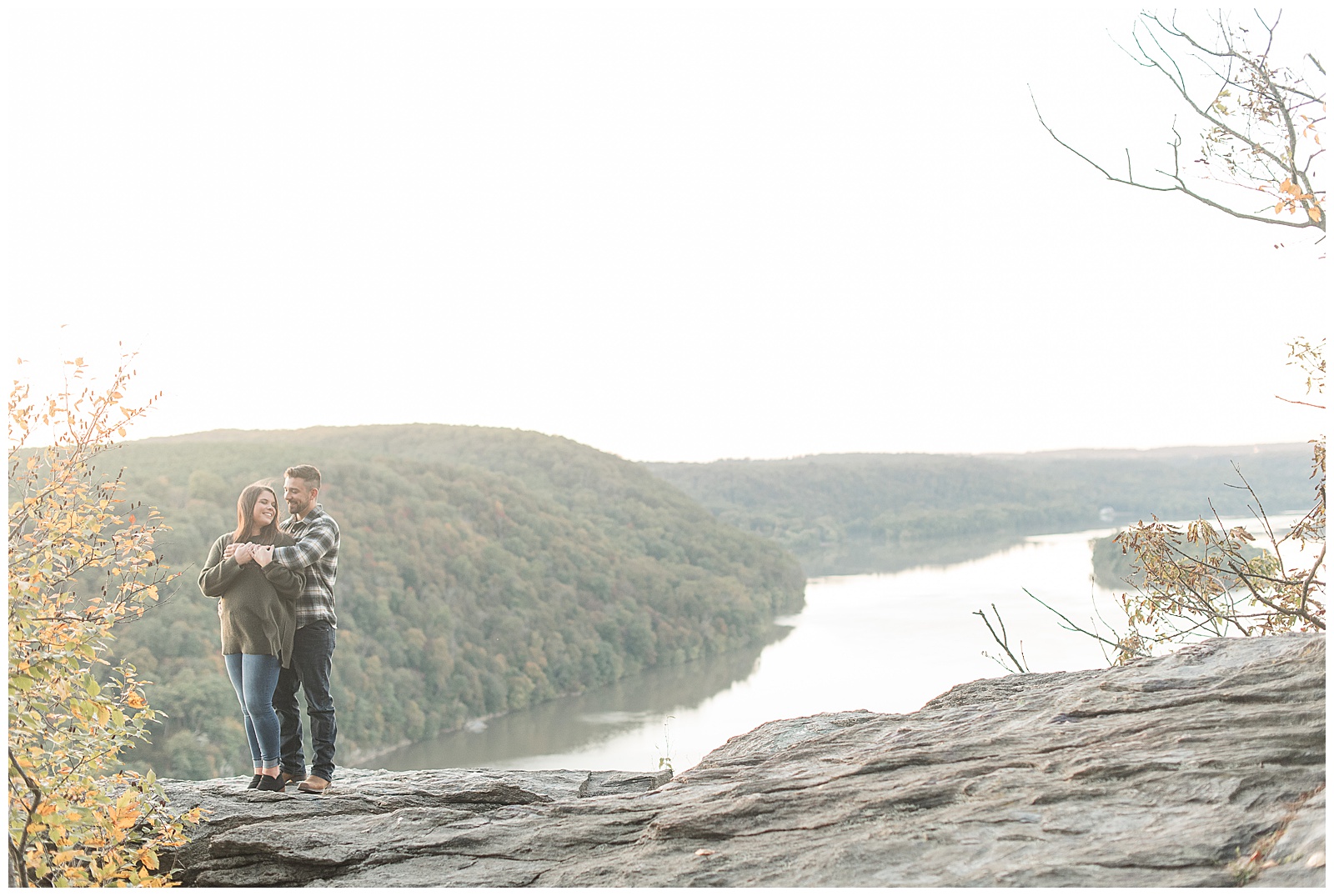 guy hugging girl from behind atop large rock hill with susquehanna river behind and below them at pinnacle overlook in holtwood pennsylvania
