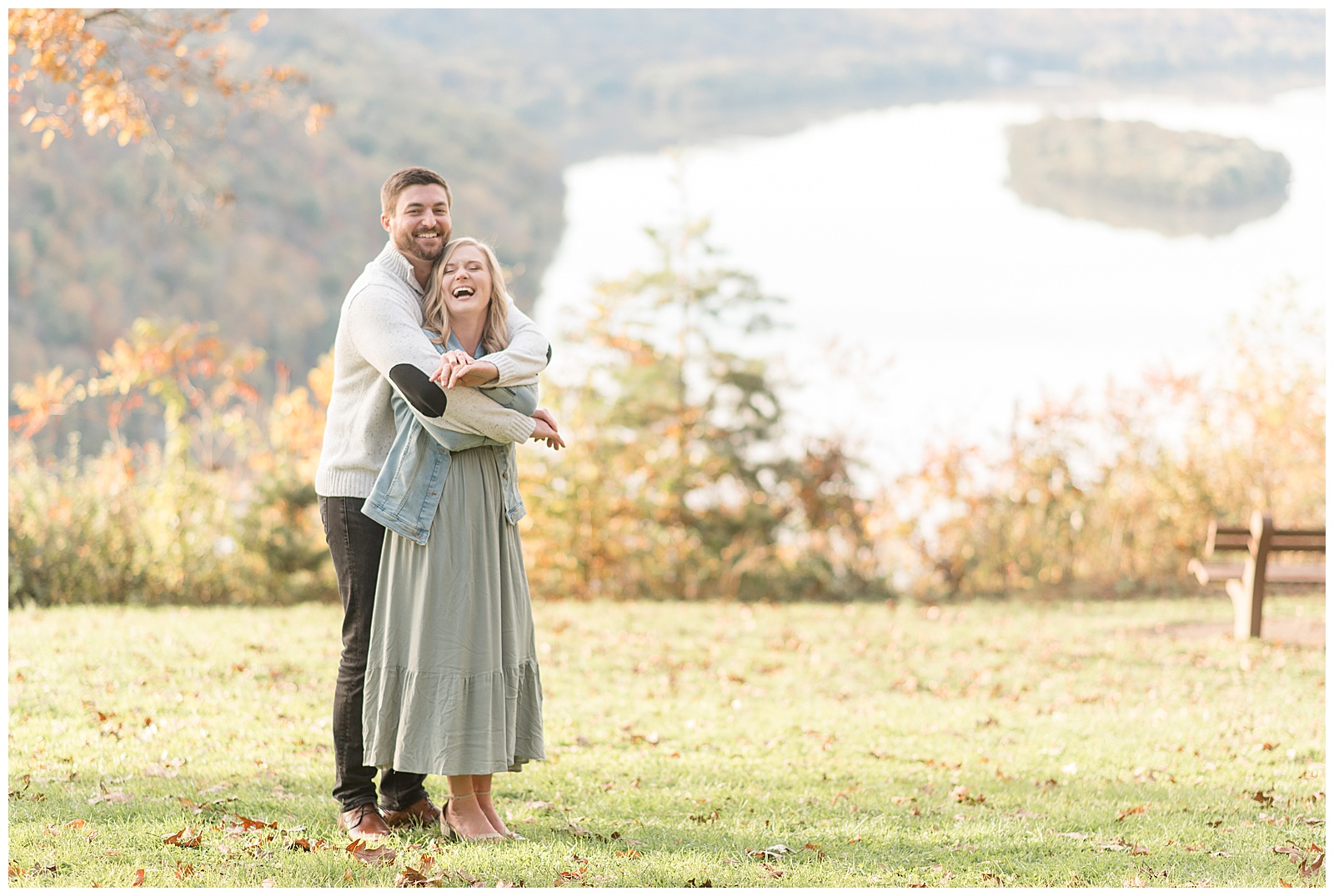 guy hugging girl from behind as she looks slightly up at him smiling on sunny fall day at pinnacle point overlook in holtwood pennsylvania