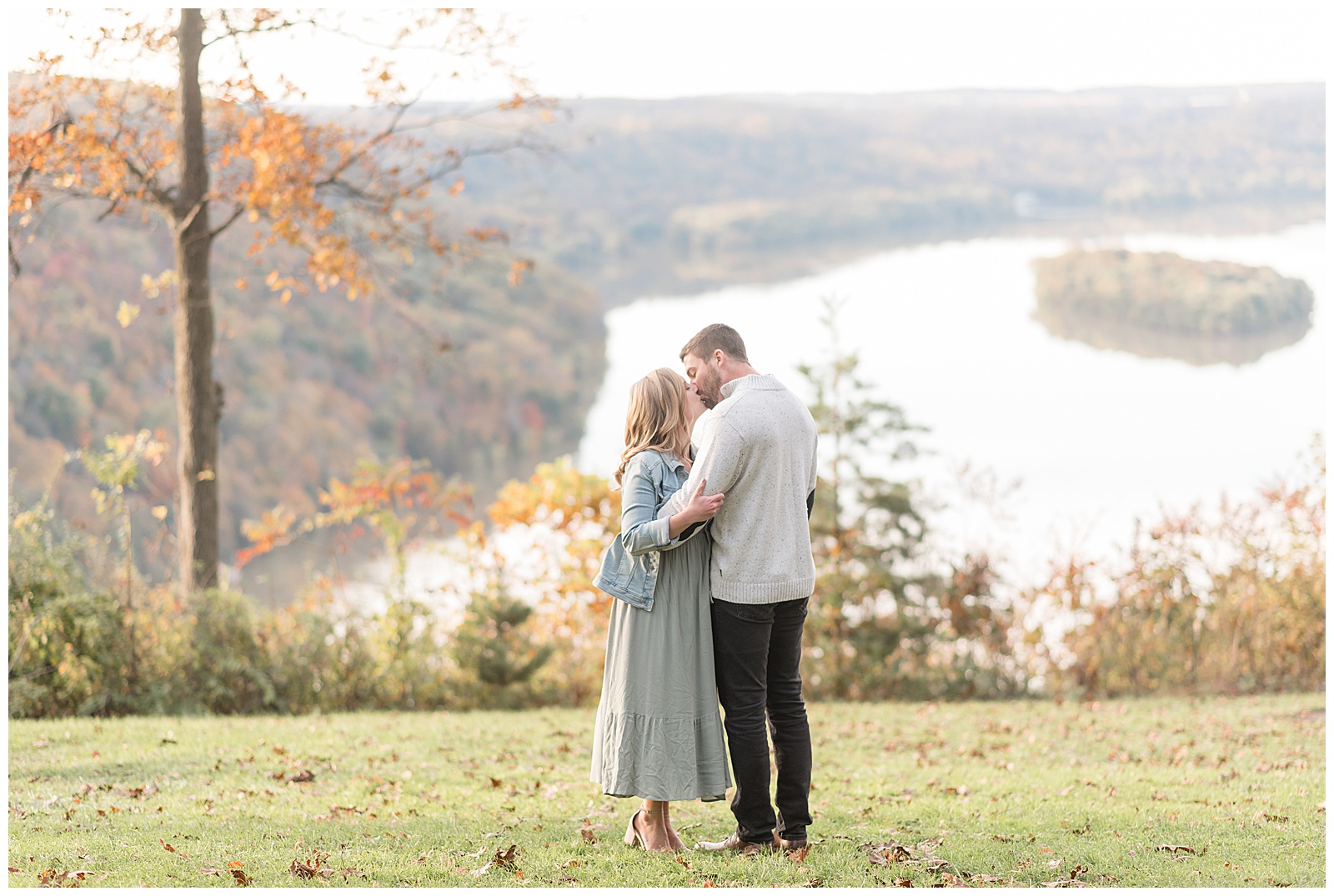 engaged couple kissing and hugging by pinnacle point overlook on sunny fall day in lancaster pennsylvania