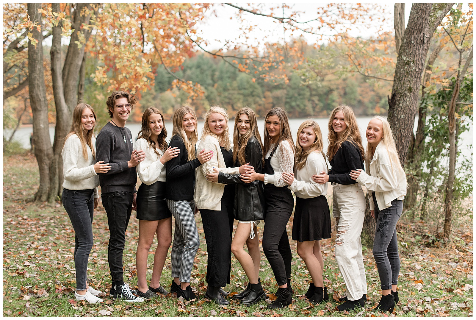 ten senior spokesmodels all wearing variations of black and ivory outfits standing close and smiling at camera at reservoir park