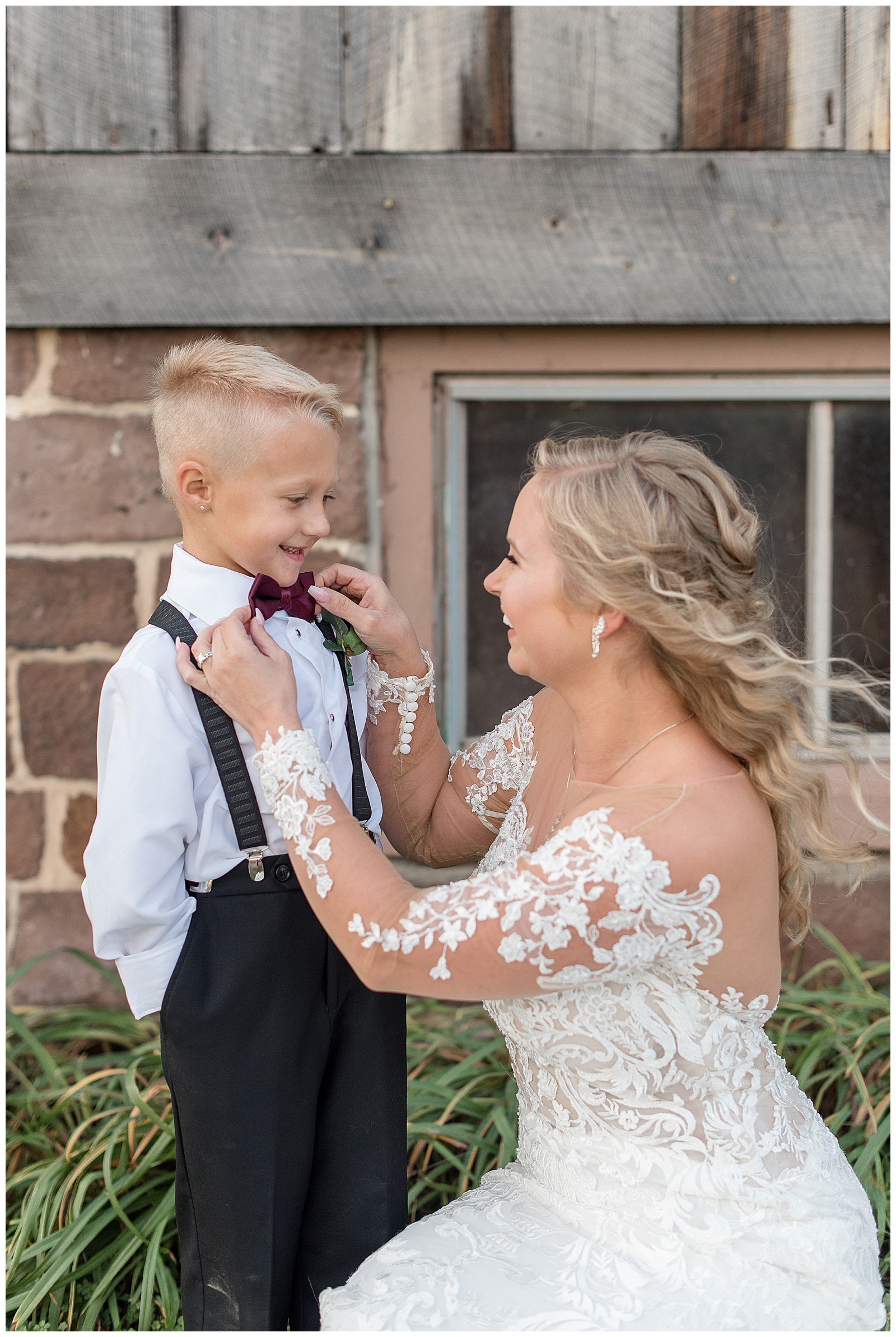 bride adjusts her son's bowtie as they both smile and he has his hands in his pockets in york pennsylvania