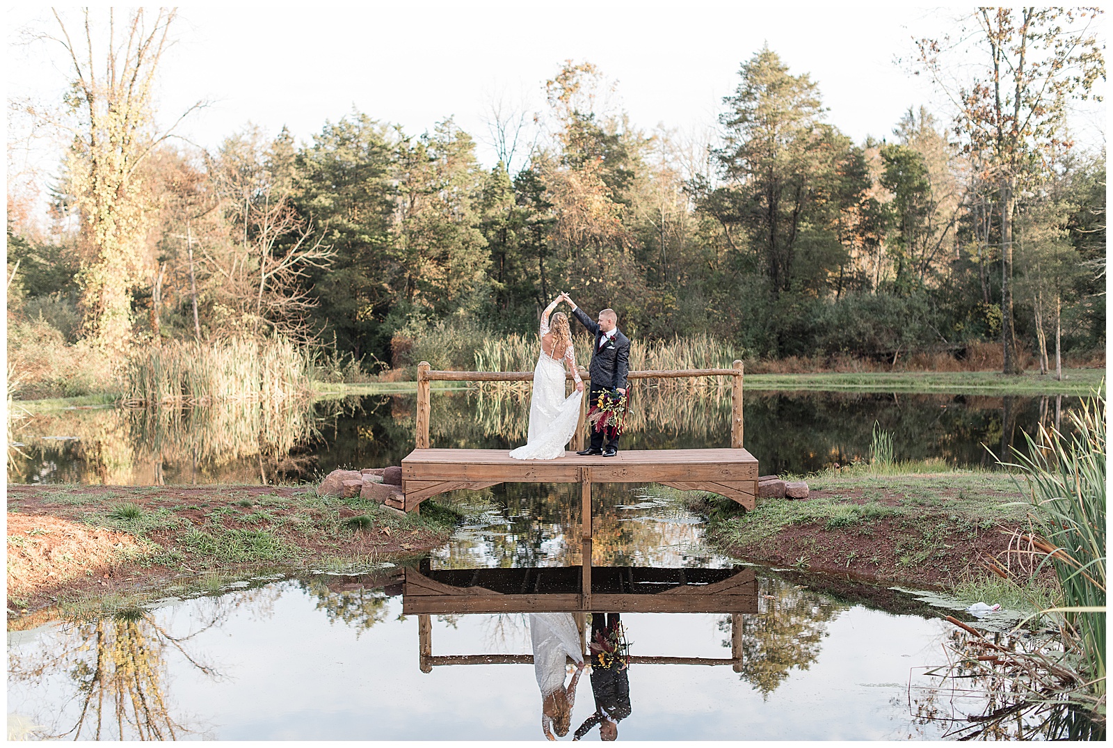groom twirling his bride under his right arm while standing on dock by pond at walnut grove farms