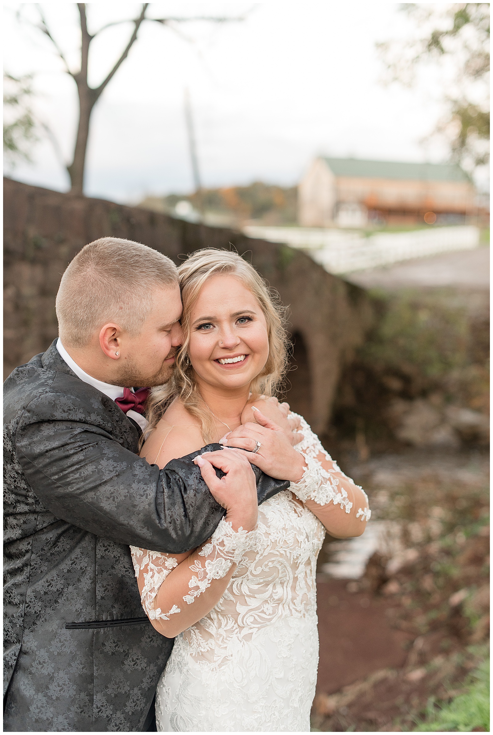 groom resting forehead against bride's as she smiles at camera and holds onto his farms wrapped around her in dover pennsylvania