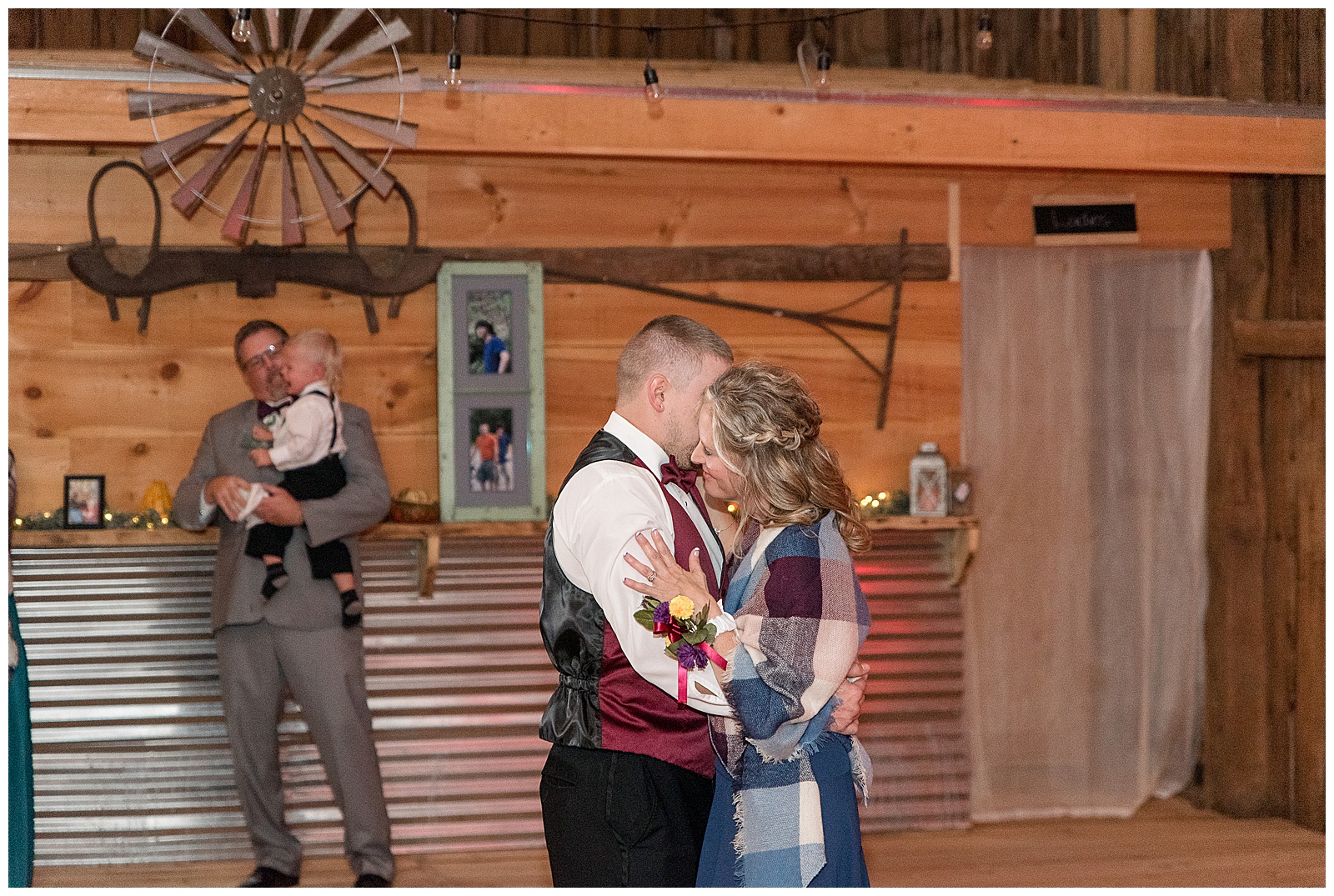 groom dancing with his mom as they hug inside rustic barn at walnut grove farms