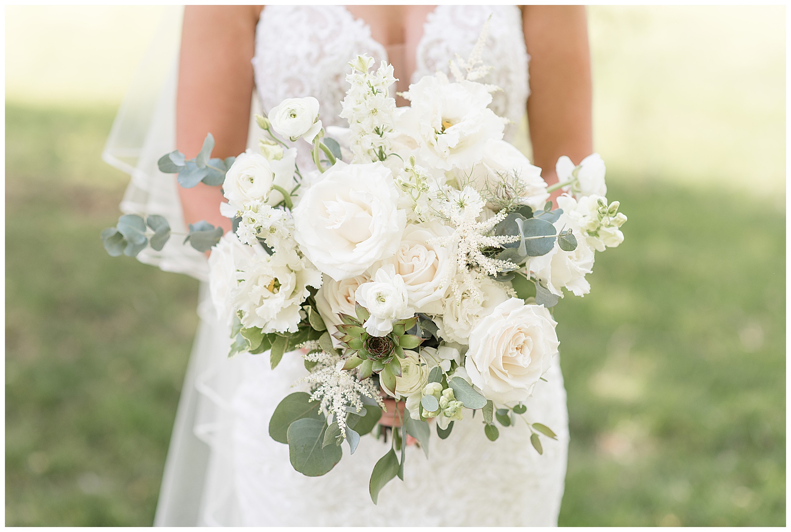 close up photo of bride's bouquet filled with white roses, other white flowers, and silver dollar eucalyptus