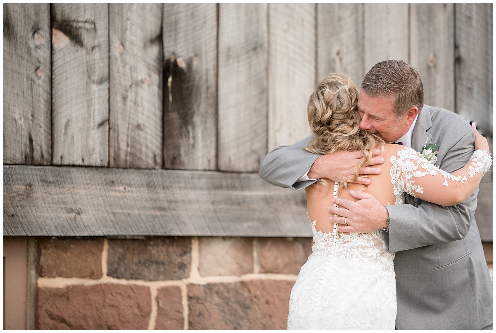 bride hugging her father during first look moment by rustic barn at walnut grove farms in york pennsylvania