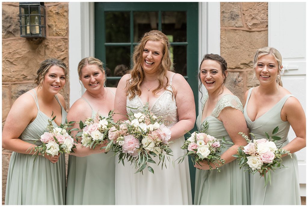 bride surrounded by her bridesmaids wearing mint green dresses all holding bouquets in lititz pennsylvania