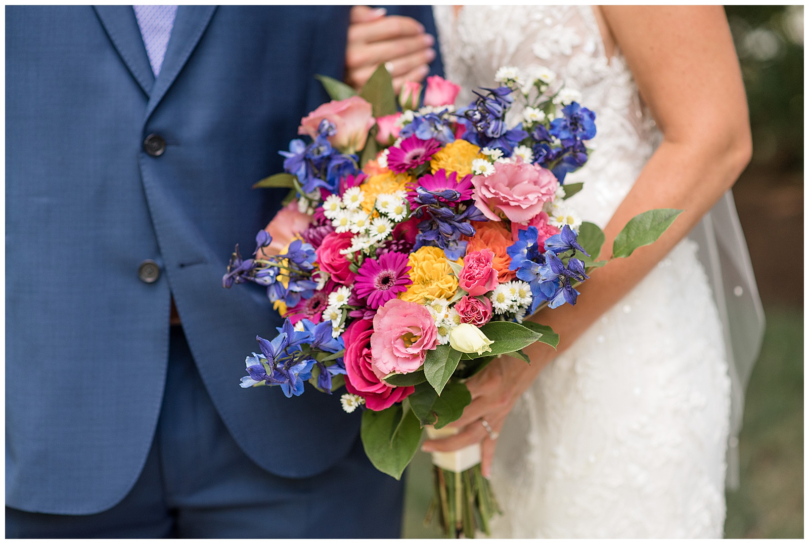 close up photo of bride's beautiful colorful bouquet of flowers as she holds onto her groom in leola pennsylvania