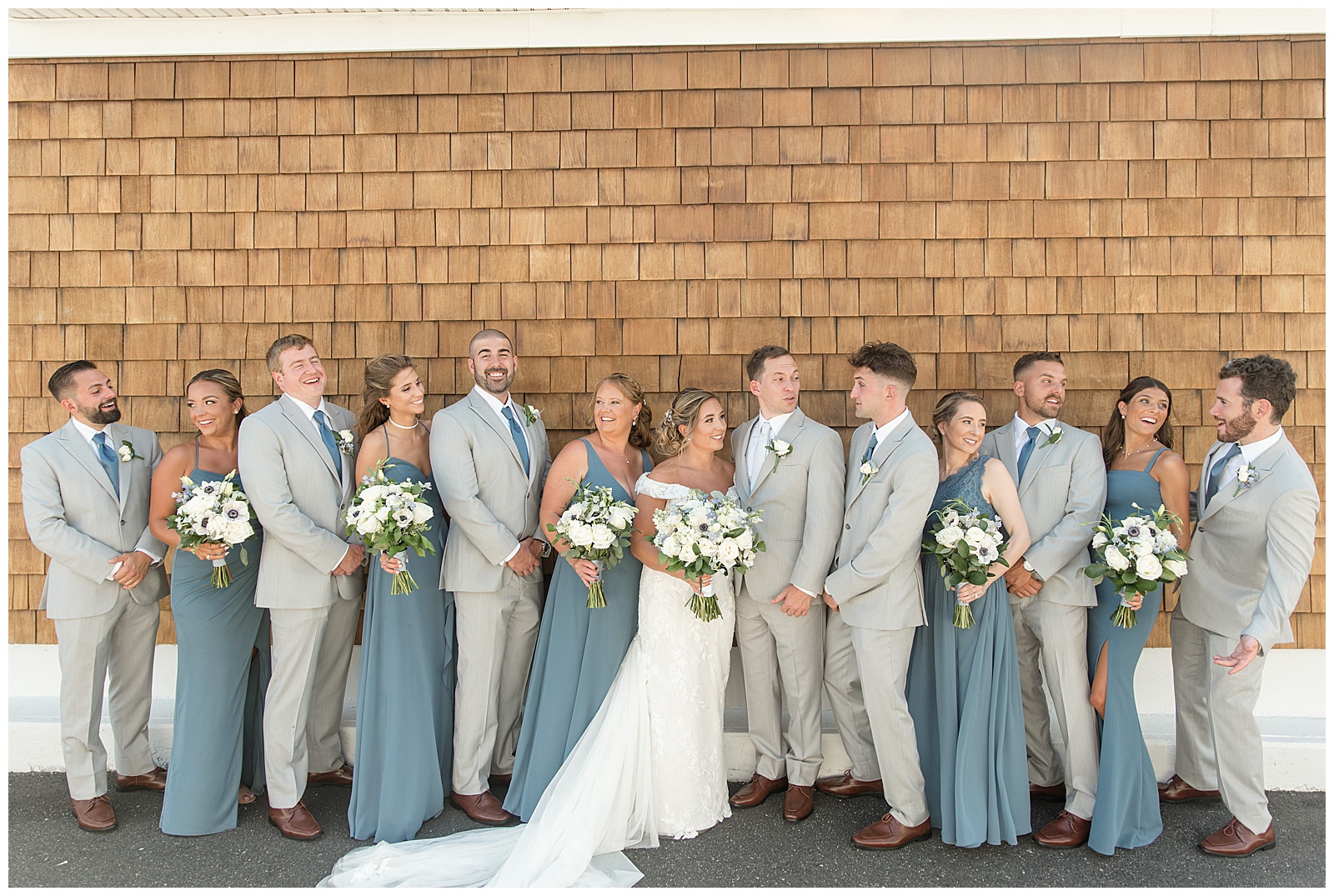 couple with their bridal party all smiling and looking in different directions on sunny summer day in long island, new york