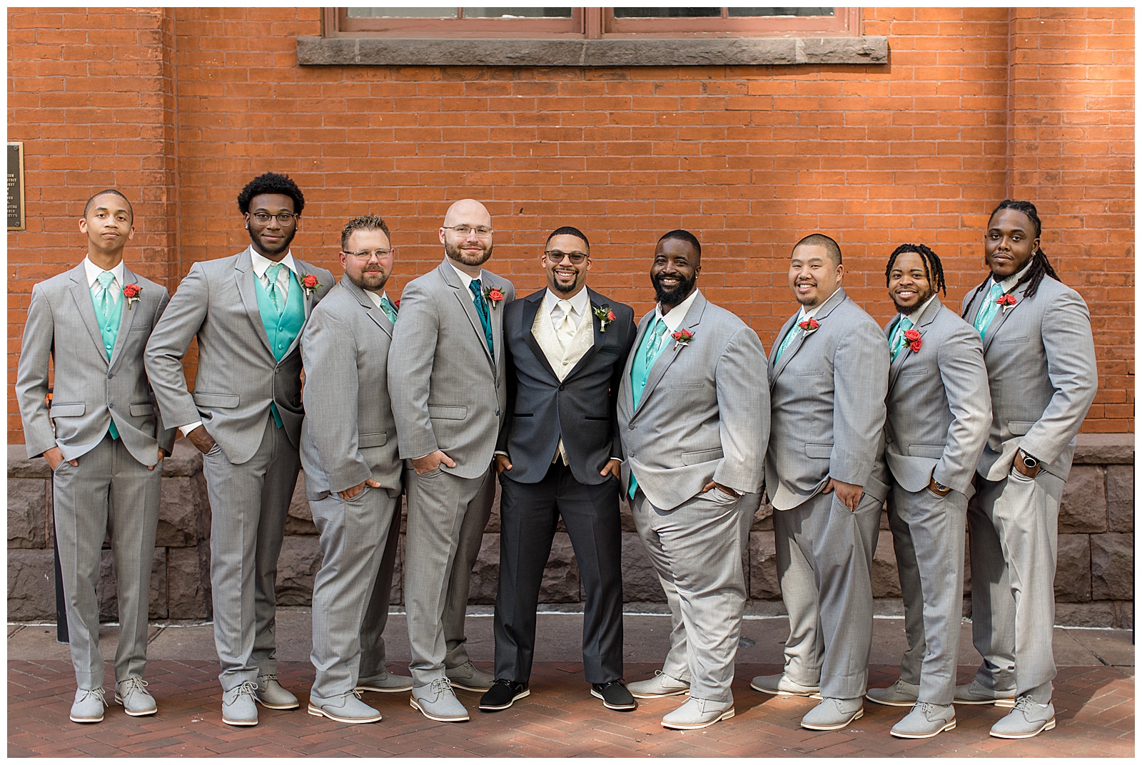 groom in black tux with his six groomsmen in light gray suits with teal vests and ties at central market in downtown lancaster