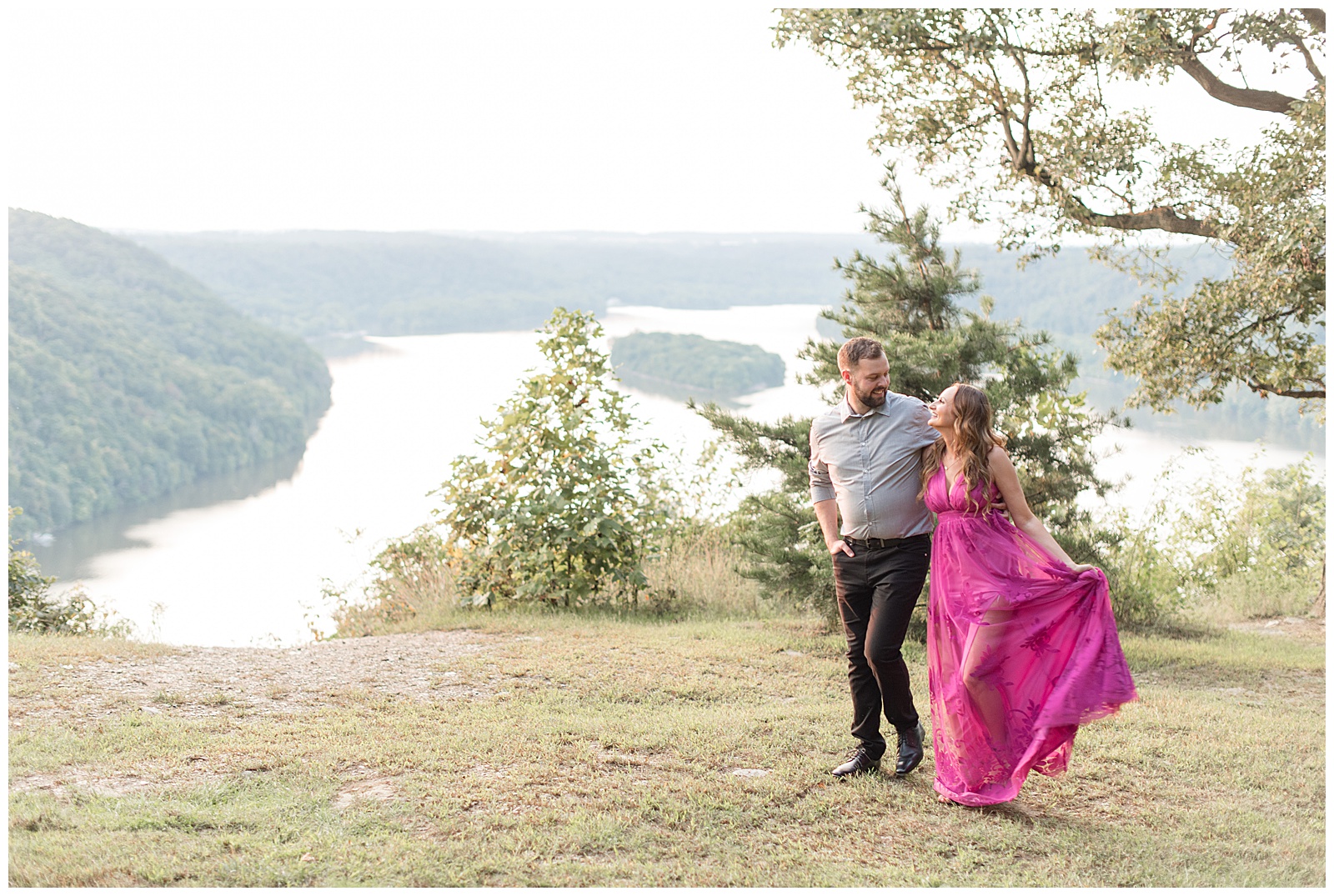 engaged couple hugging as they walk and smile atop pinnacle point overlook by susquehanna river
