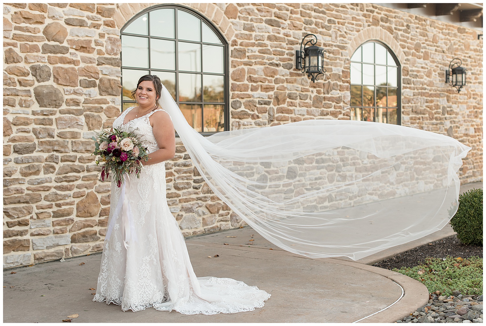 bride in her sleeveless v-neck white wedding gown with long white veil blowing in the breeze in berks county