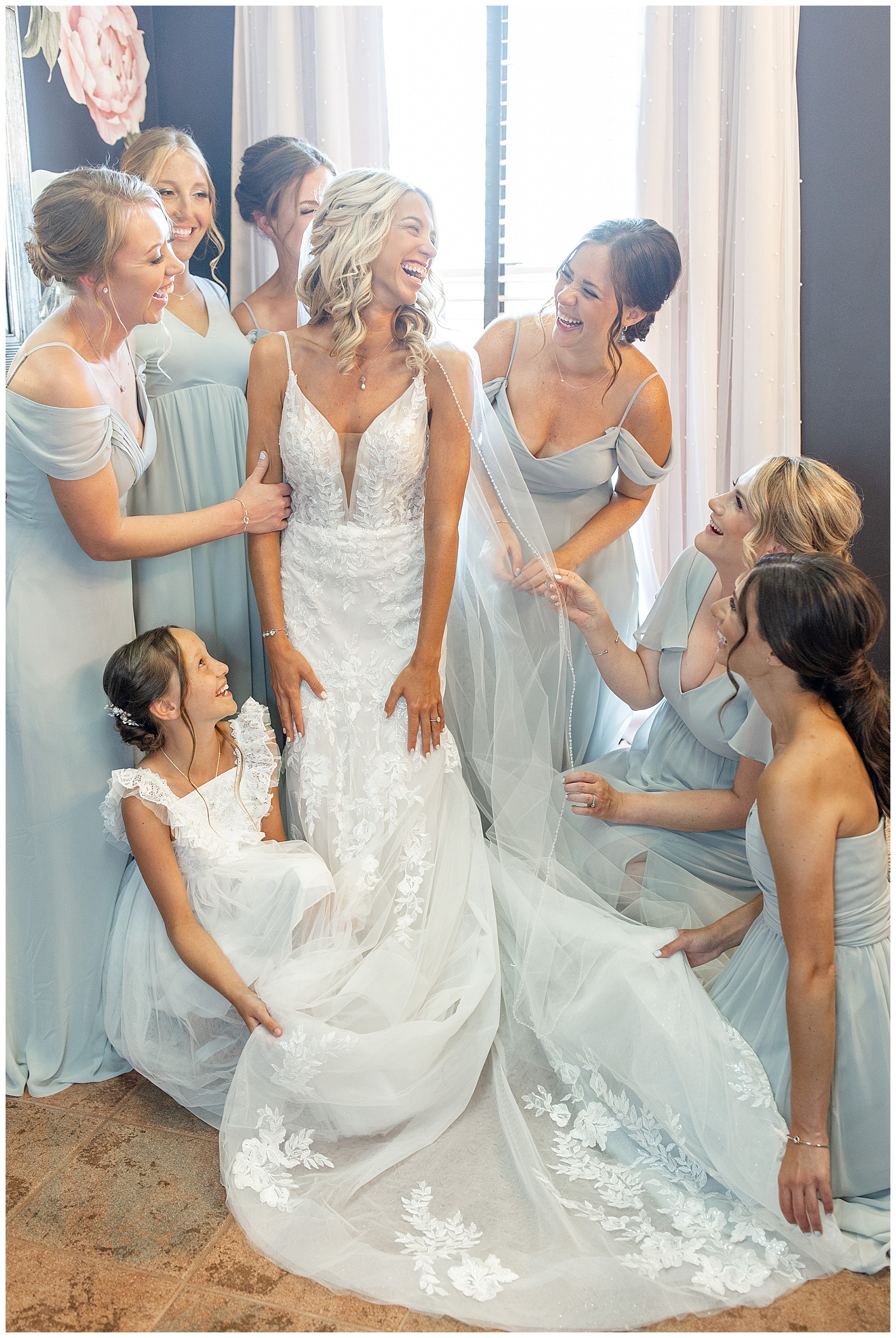 bride surrounded by her bridesmaids who are all wearing light blue gowns in bridal suite at the links at gettysburg