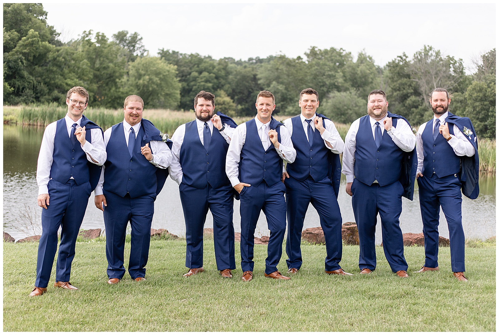 groom with his six groomsmen all in navy blue suits with vests walking towards camera at the links at gettysburg