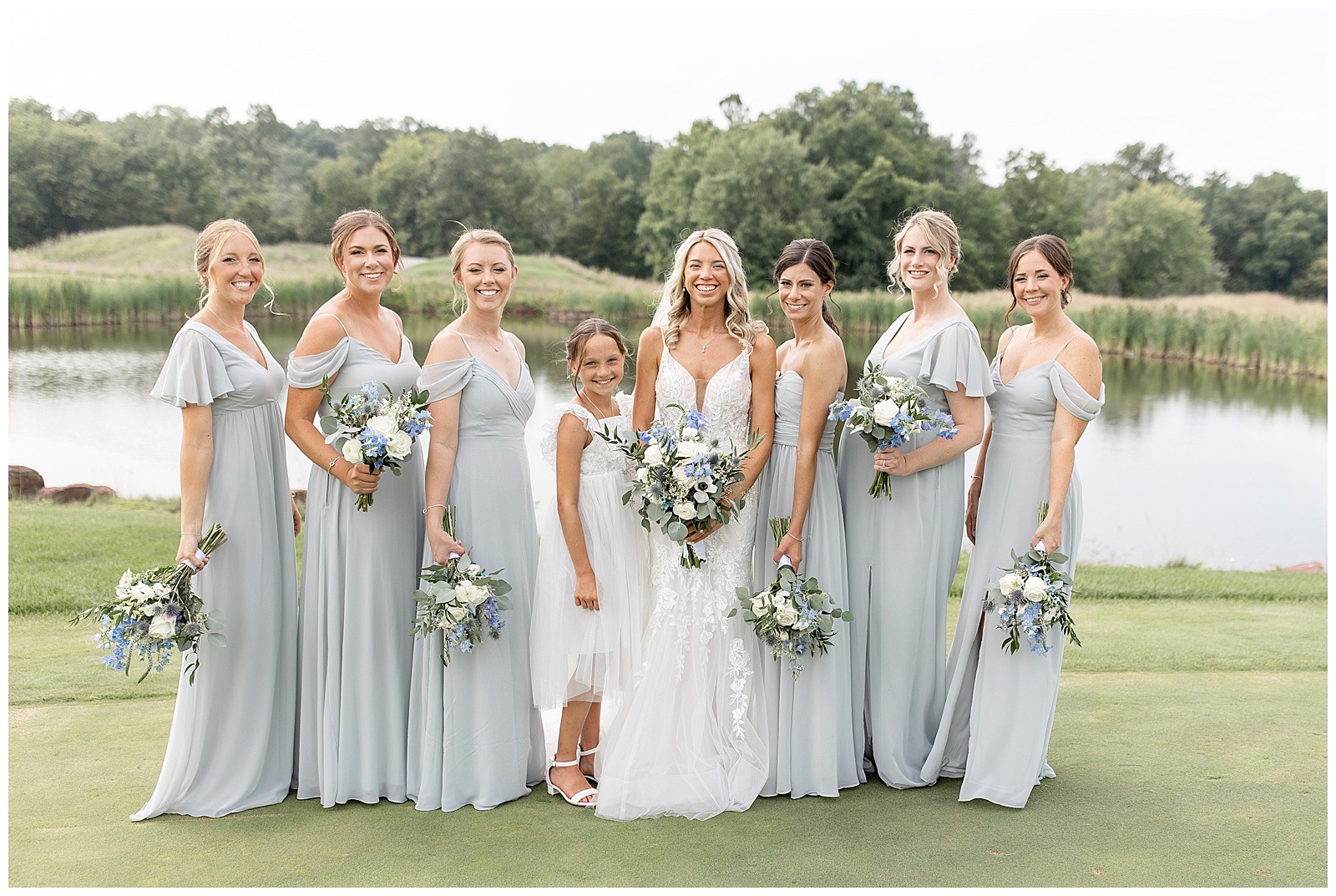 bride surrounded by her six bridesmaids and flower girl by pond at the links at gettysburg