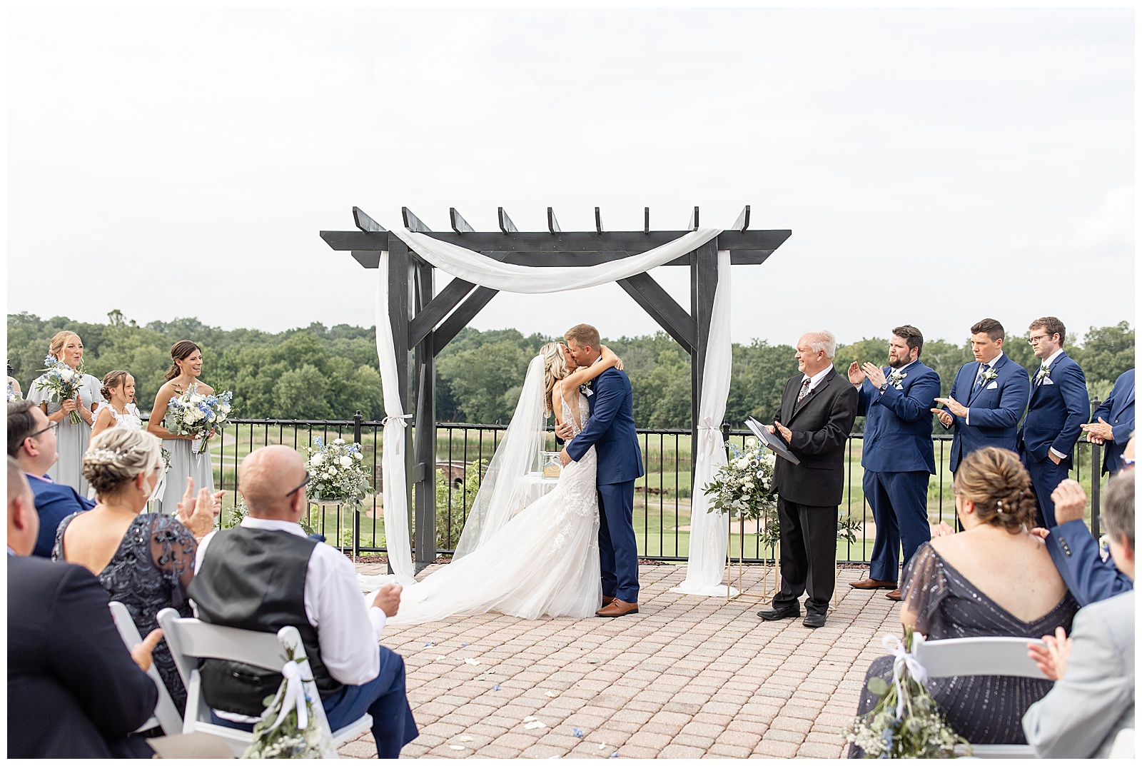 couple sharing their first kiss during outdoor wedding ceremony under wooden display at the links at gettysburg