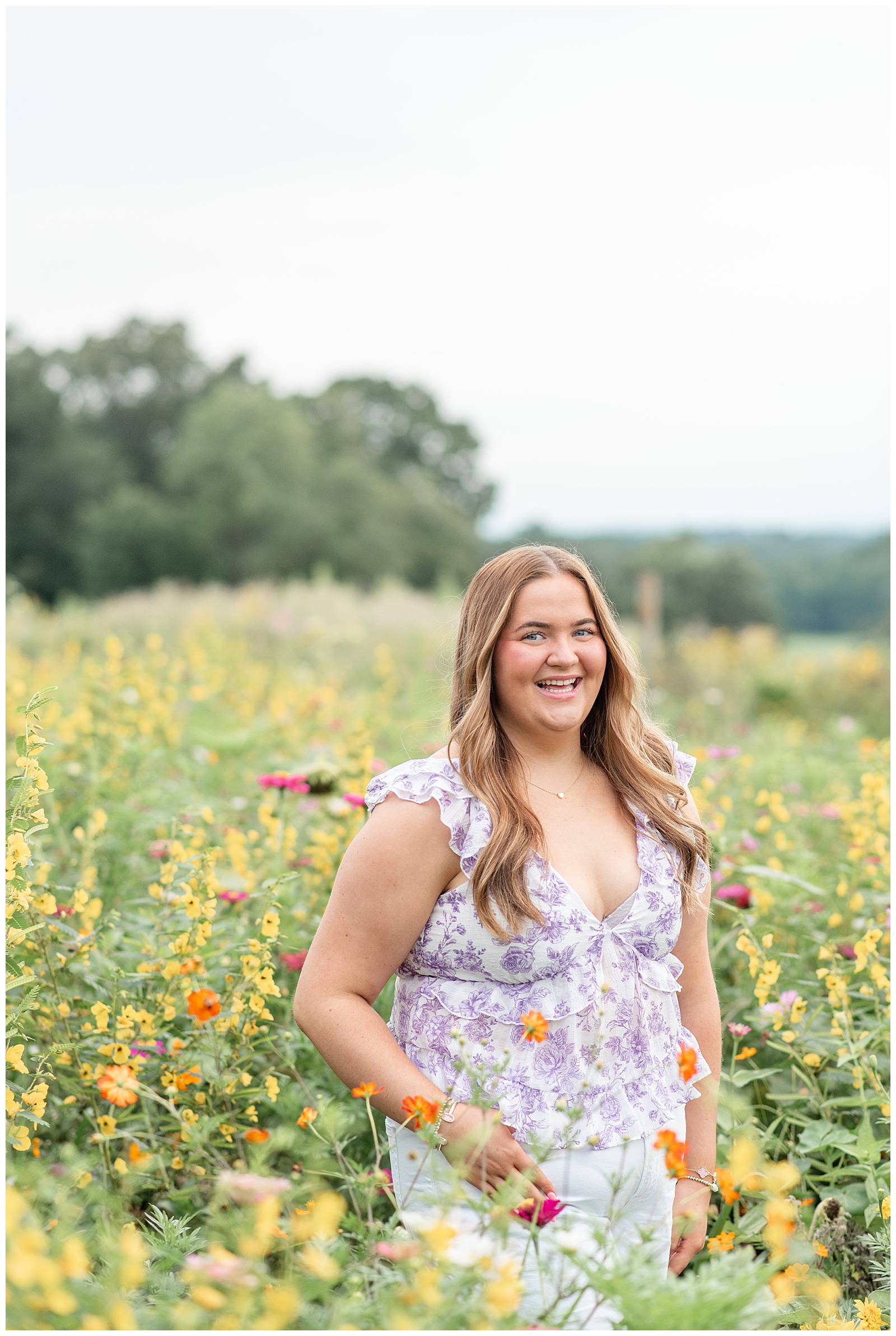 senior girl standing in field of wildflowers in lancaster county pennsylvania