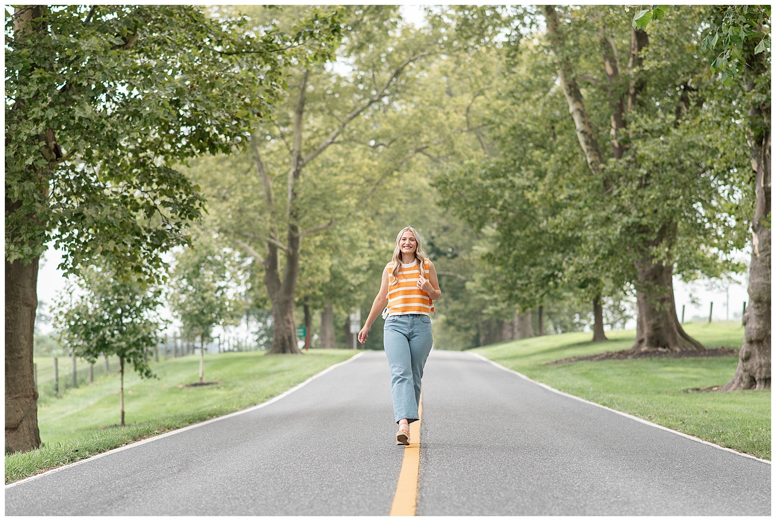 senior girl walking on yellow line in middle of road for this Masonic Village Summer Senior Session