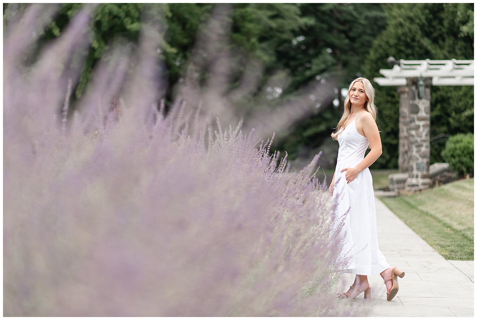 senior girl standing in walkway with lavender plant in front of her for this Masonic Village Summer Senior Session