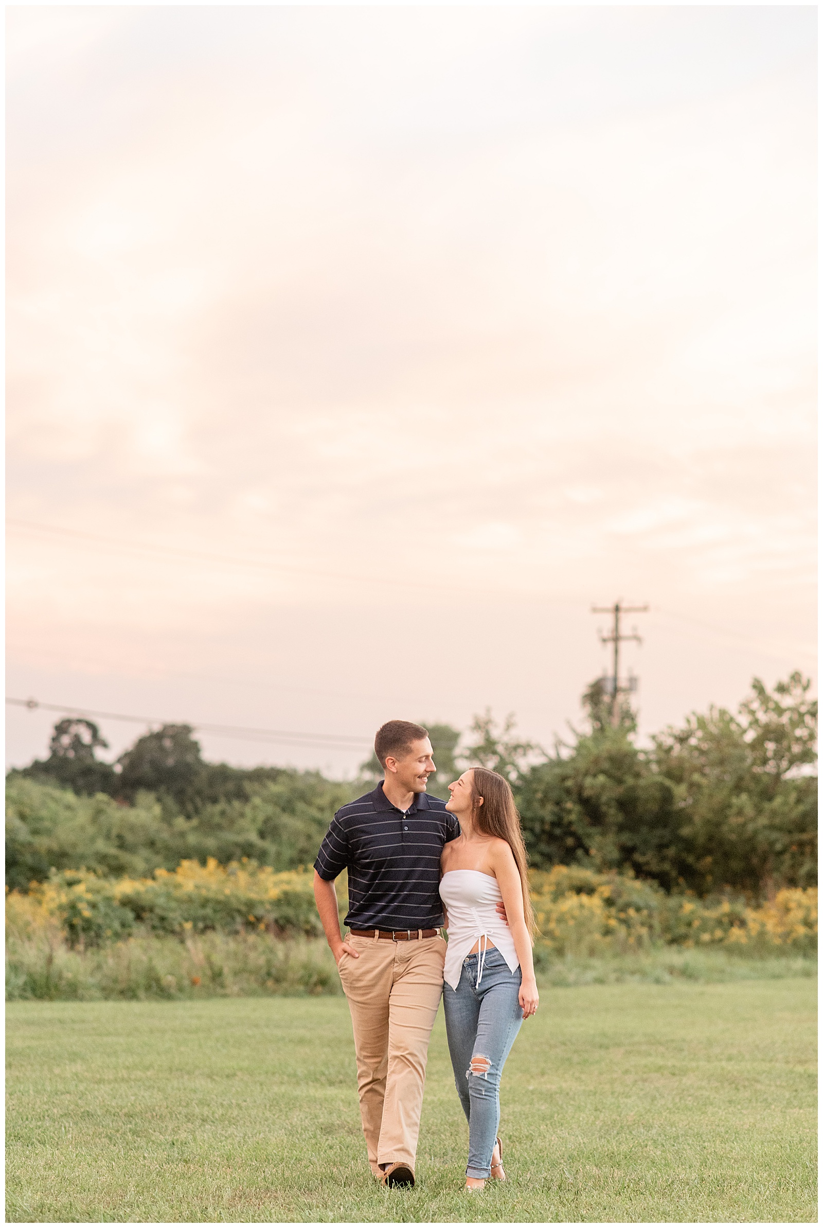 engaged couple with arms around each other walking towards camera for this Fall Overlook Park Engagement Session