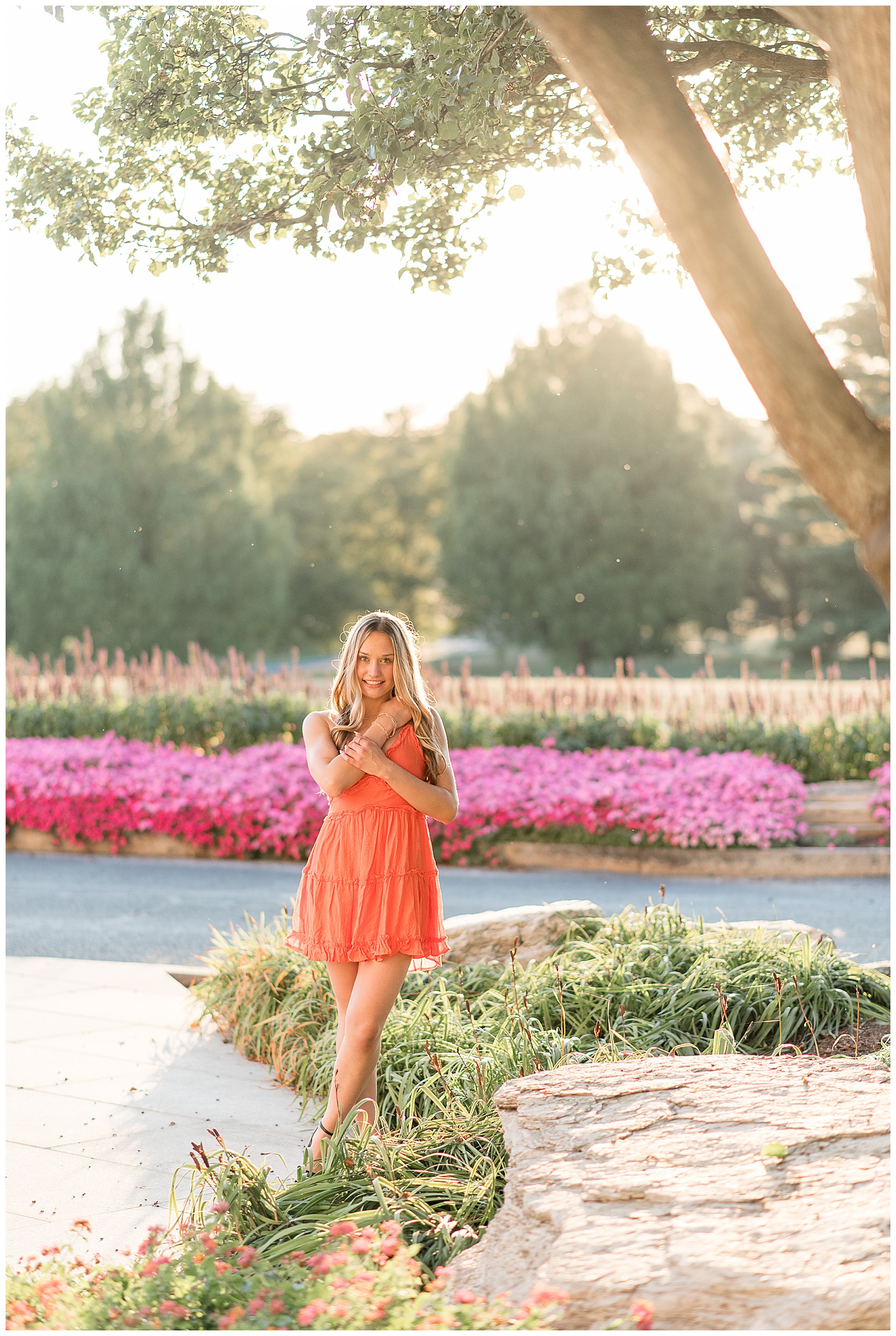 senior girl standing along path with colorful flowers behind her for this Founders Hall Summer Senior Session