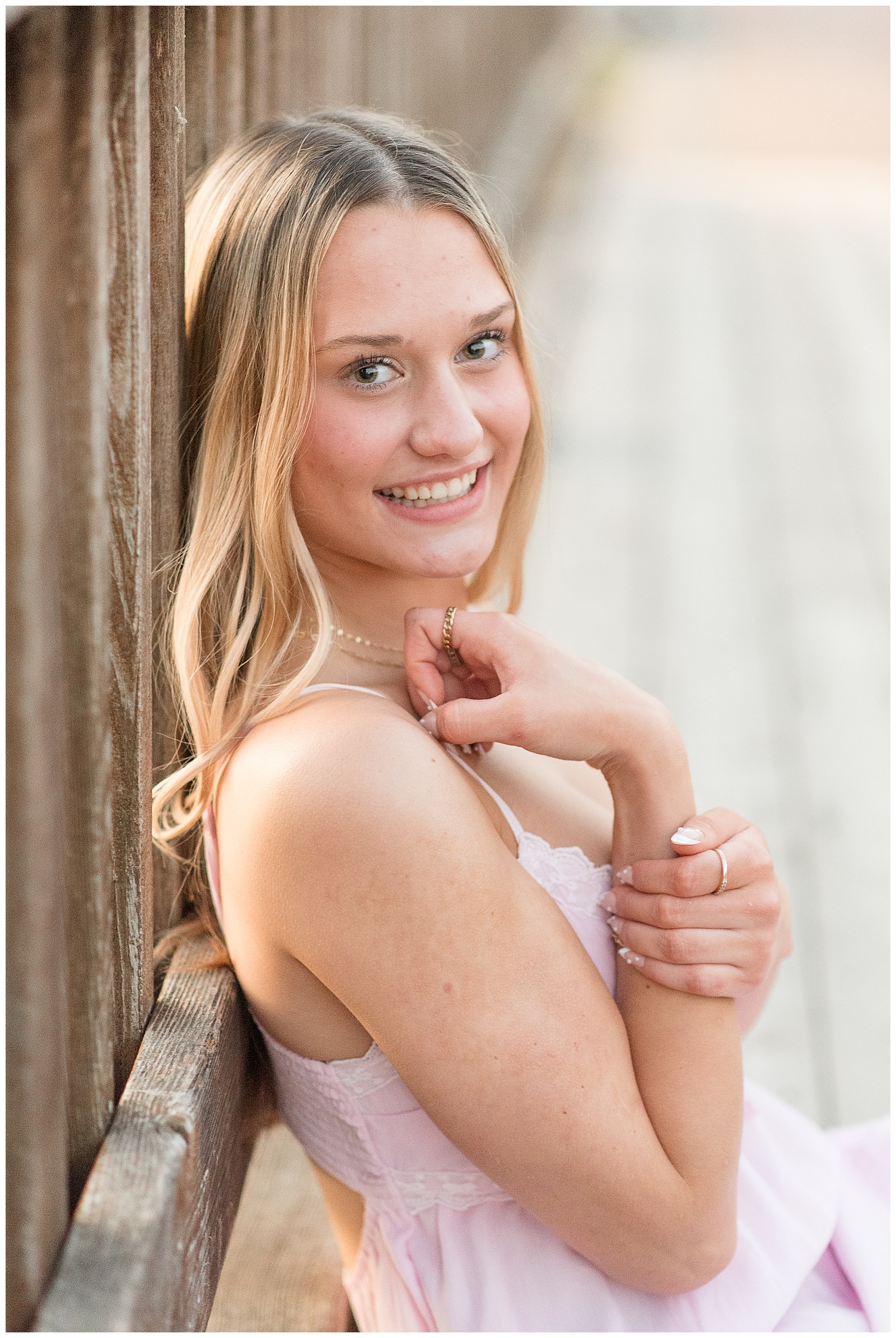senior spokesmodel leaning back against wooden fence for this Founders Hall Summer Senior Session