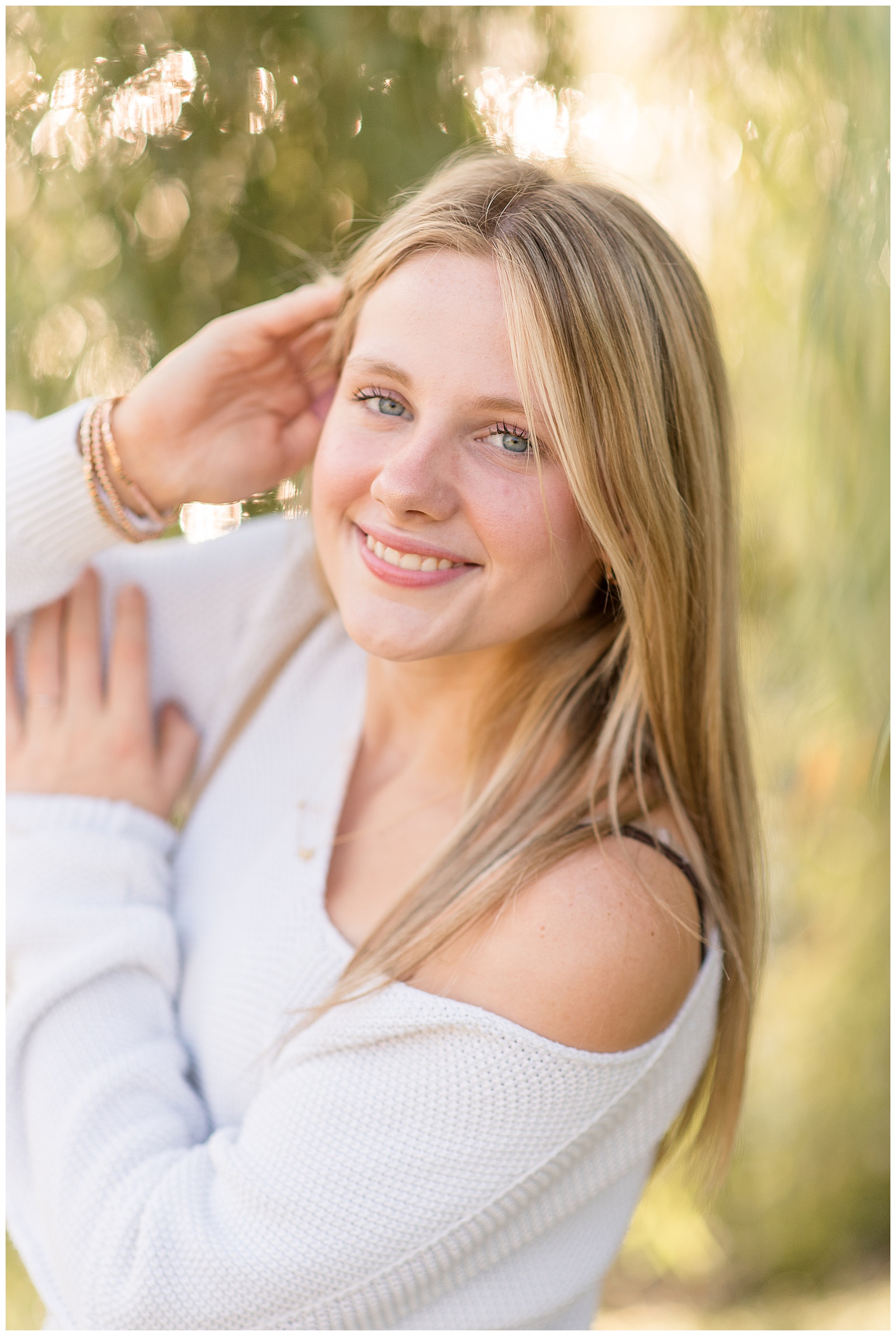 senior girl in off-the-shoulder white sweater by willow tree for this Lancaster Senior Spokesmodel Mini Sessions in central Pennsylvania