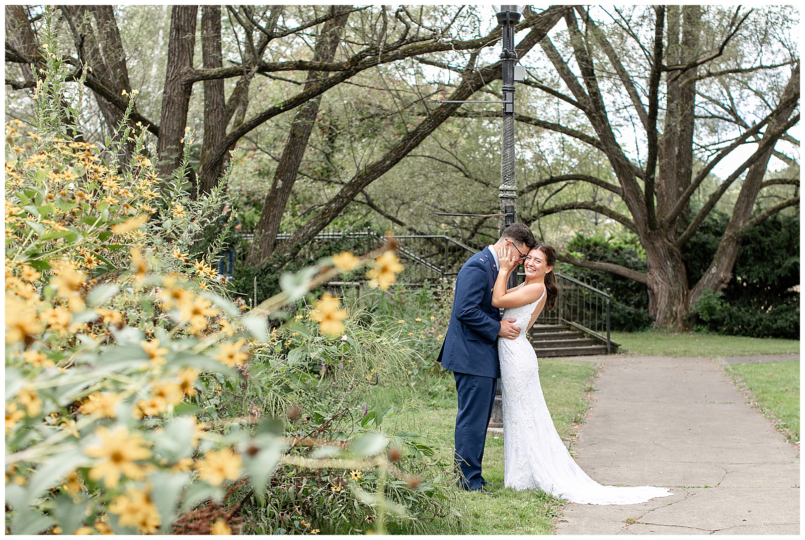 couple hugging as bride leans back by bush with yellow flowers for this Intimate Central PA Elopement