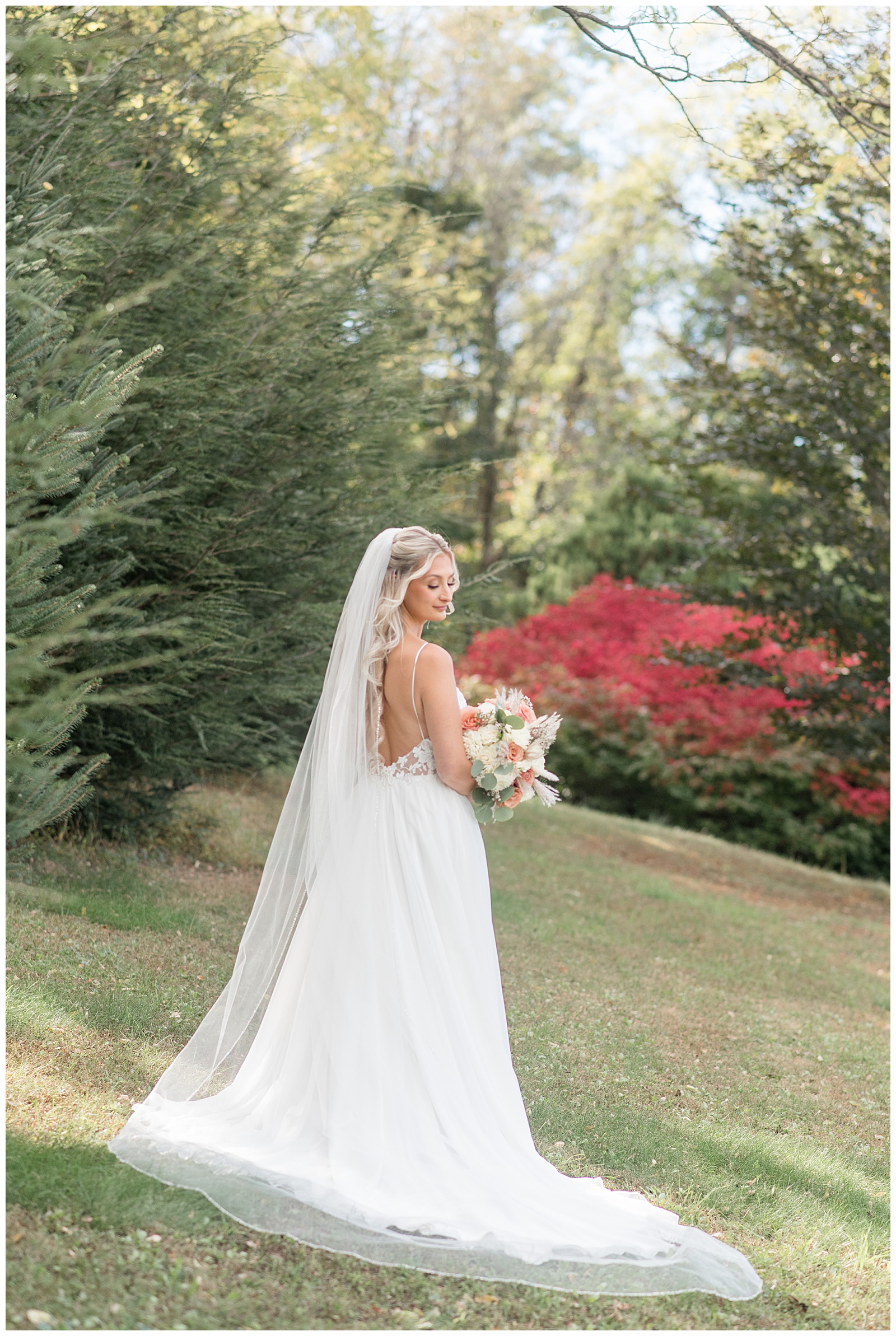 bride holding bouquet with back to camera and looking over right shoulder for this Central PA Farm Wedding