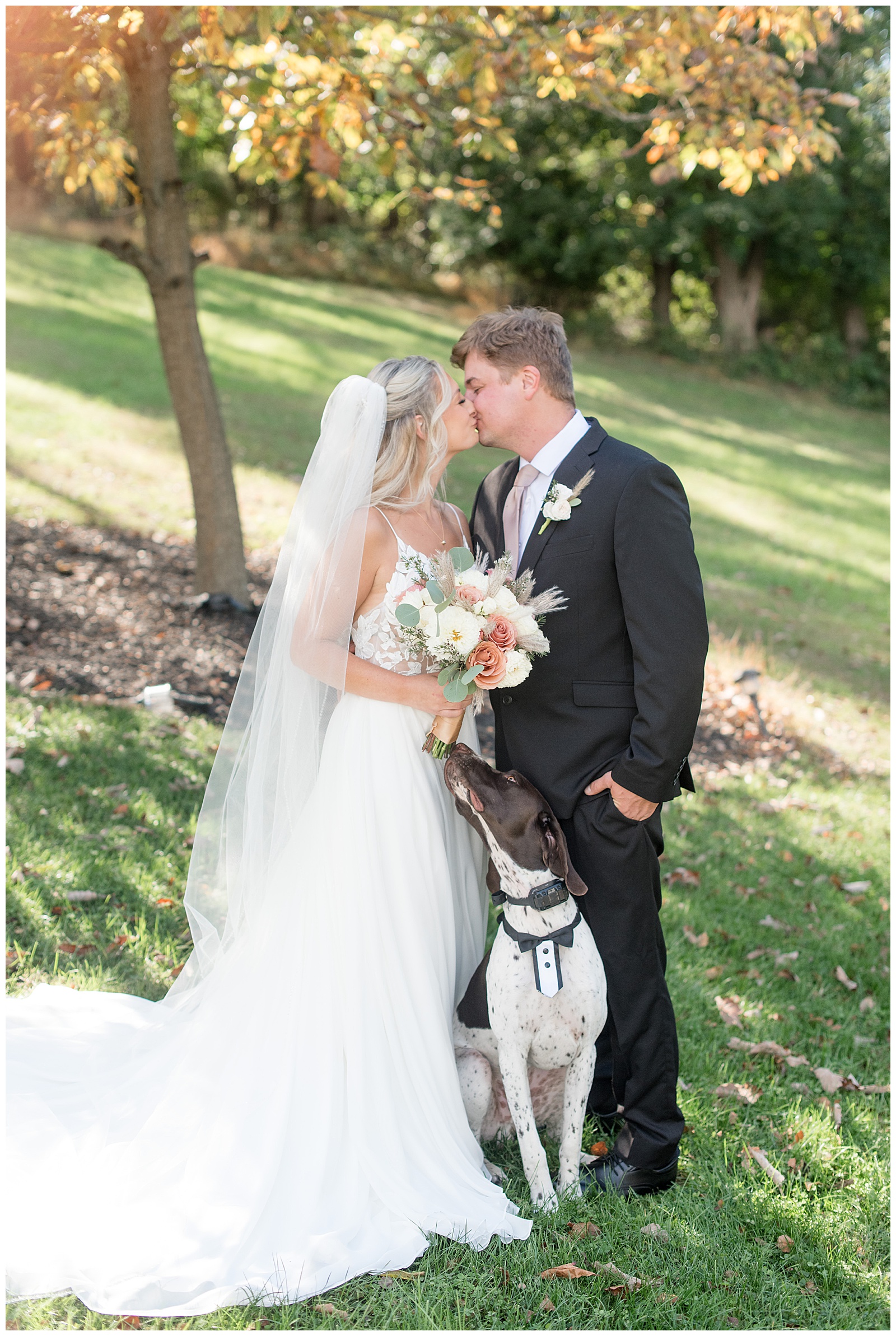couple kissing as their pup looks up at them for this Central PA Farm Wedding