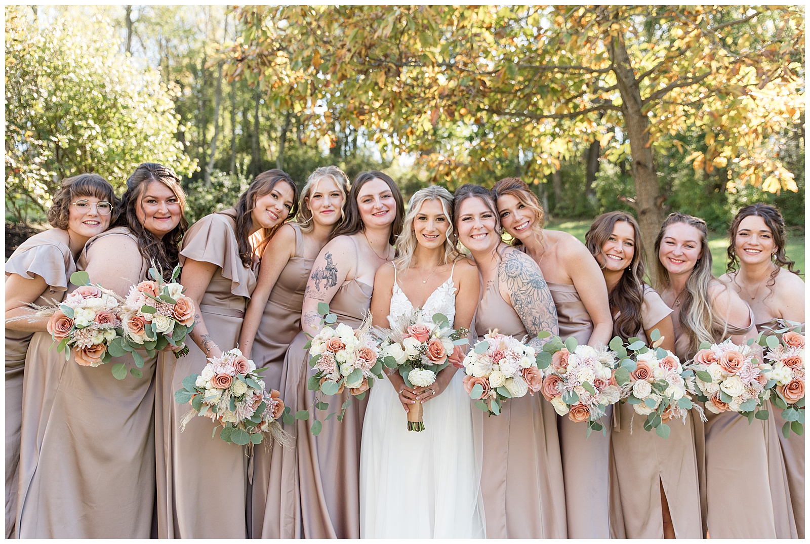 bride and bridesmaids huddled together and holding bouquets for this Central PA Farm Wedding