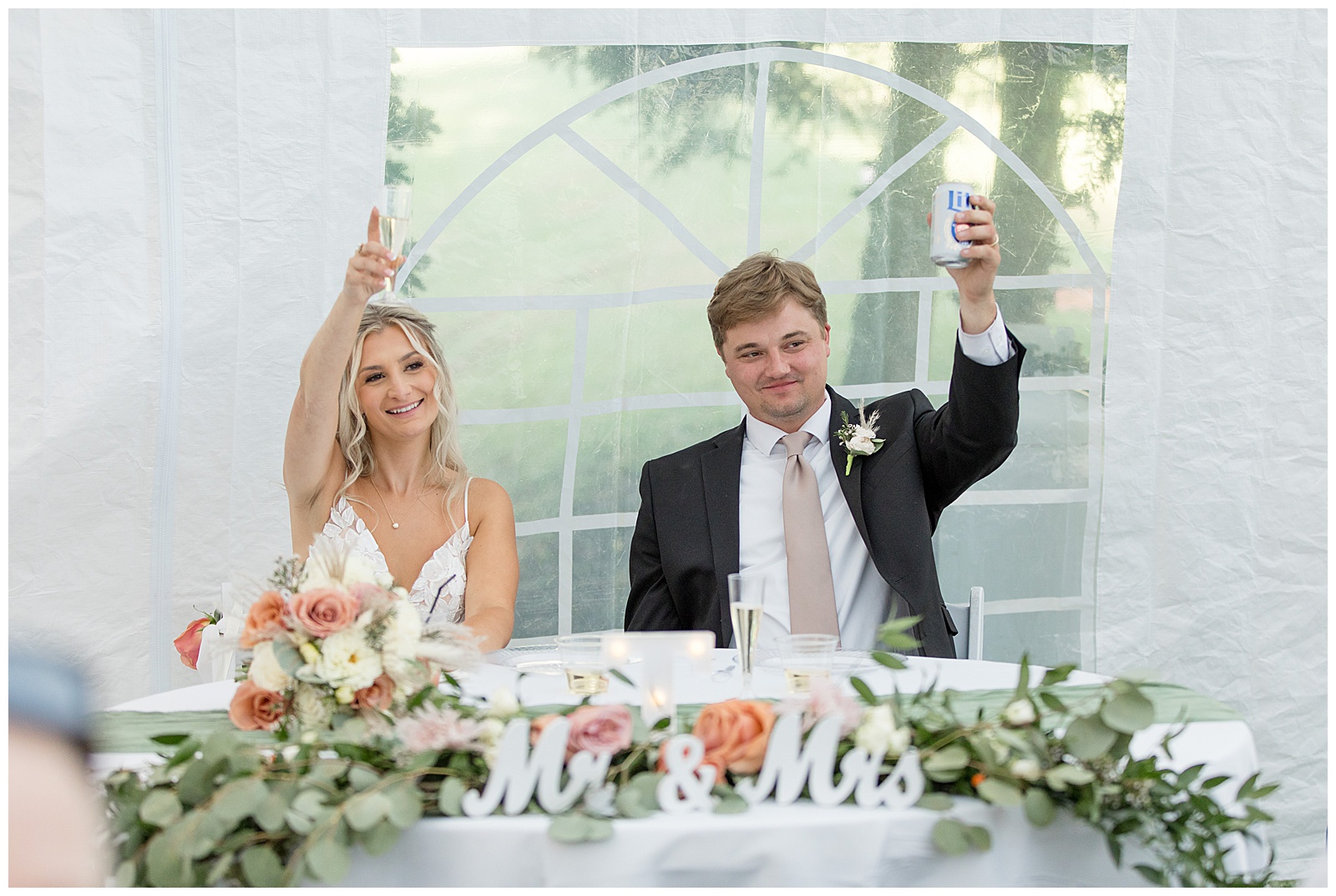 bride and groom raising their glasses for a toast during backyard tent reception for this Central PA Farm Wedding