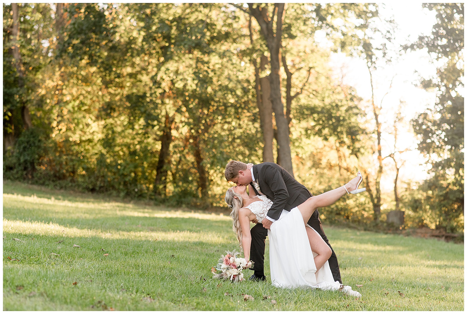 groom dipping his bride way back and kissing her for this Central PA Farm Wedding