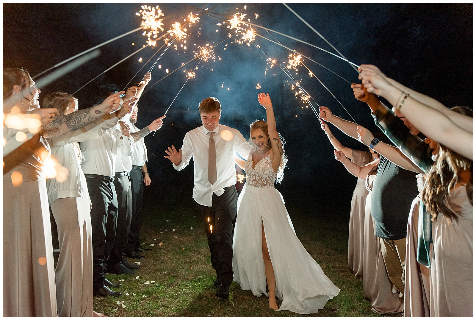wedding guests raising sparklers as couple leaves their wedding reception for this Central PA Farm Wedding