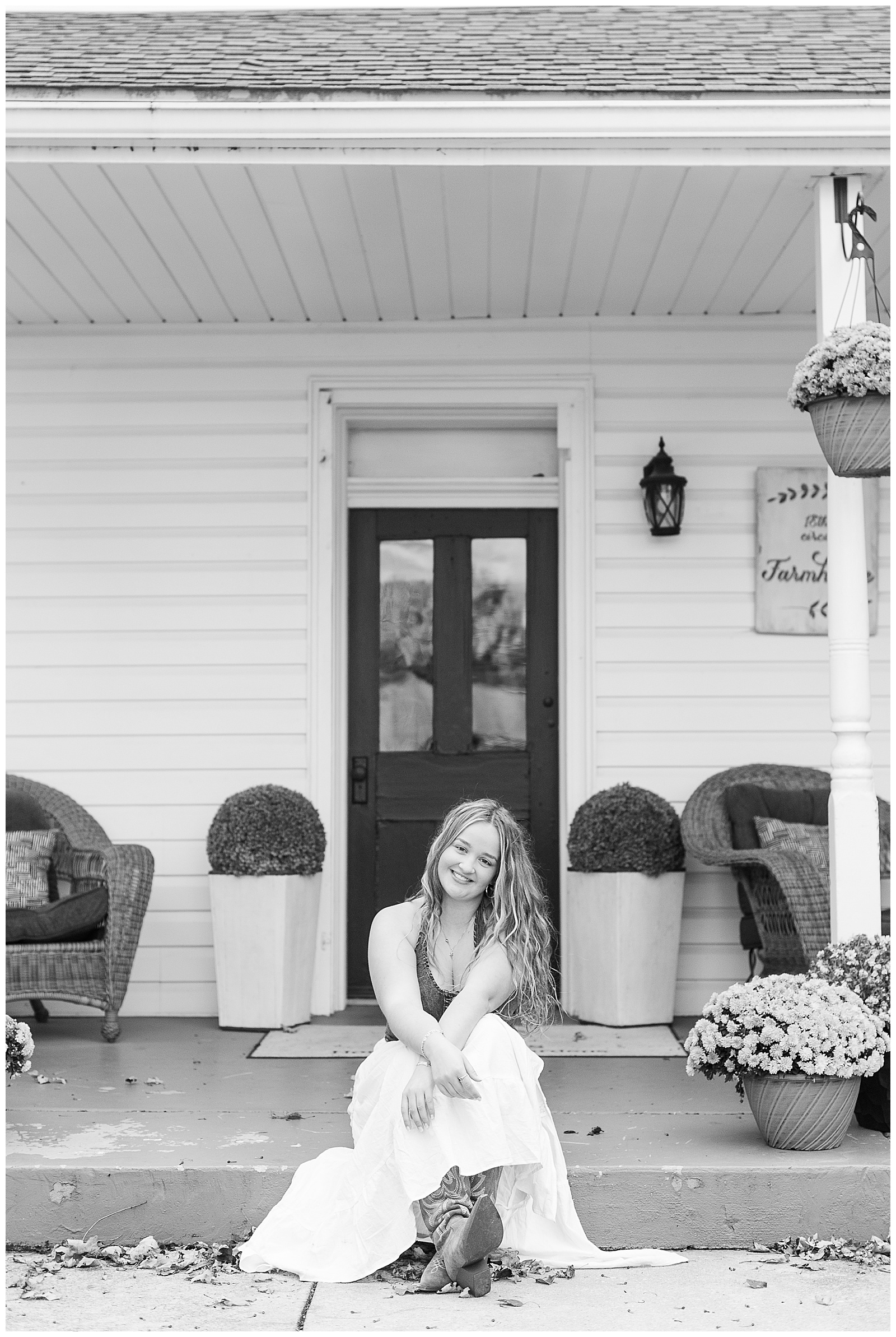black and white photo of senior girl sitting on front porch step for this Stoltzfus Homestead and Gardens Senior Session