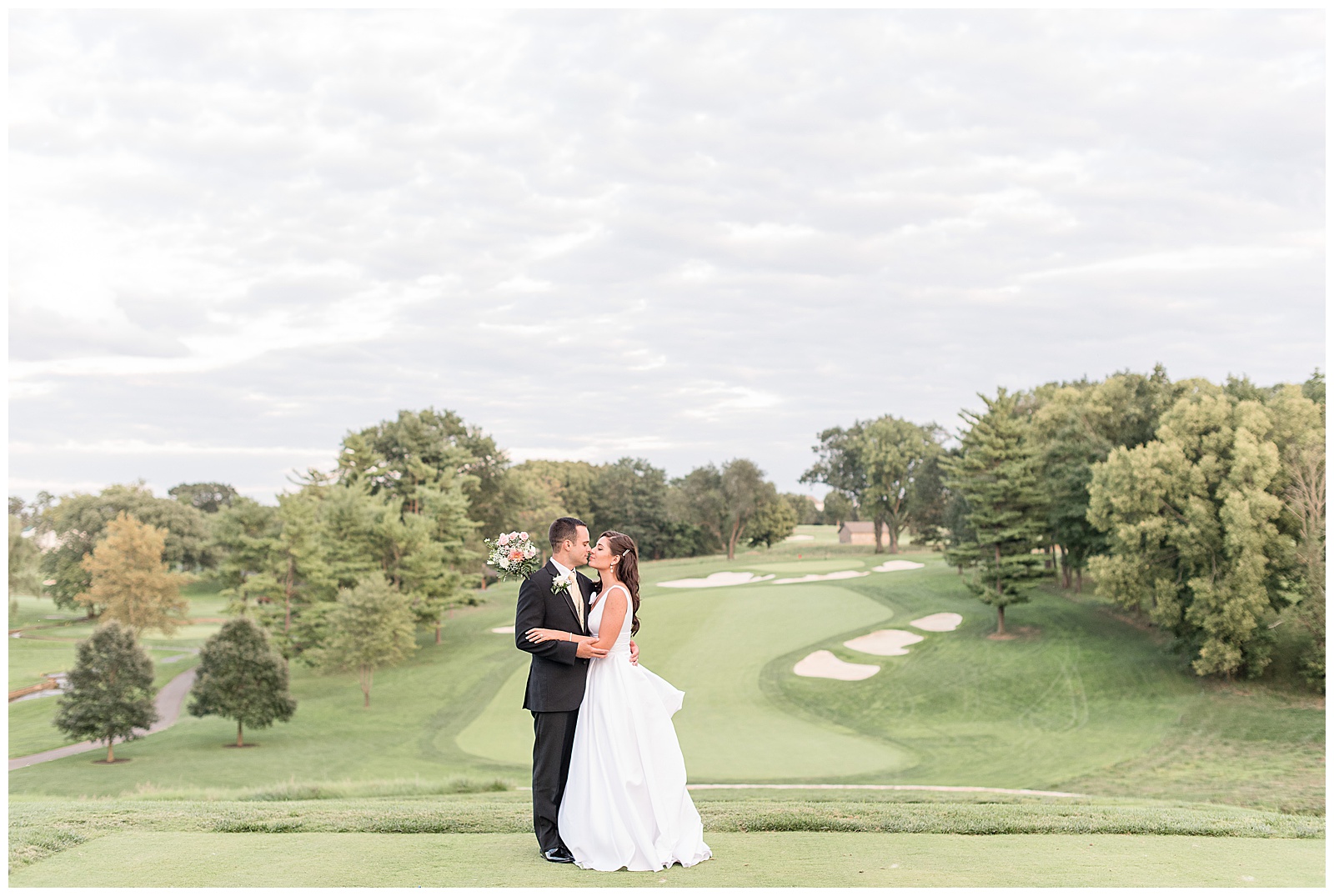 bride and groom kissing at sunset on golf green at Lancaster Country Club