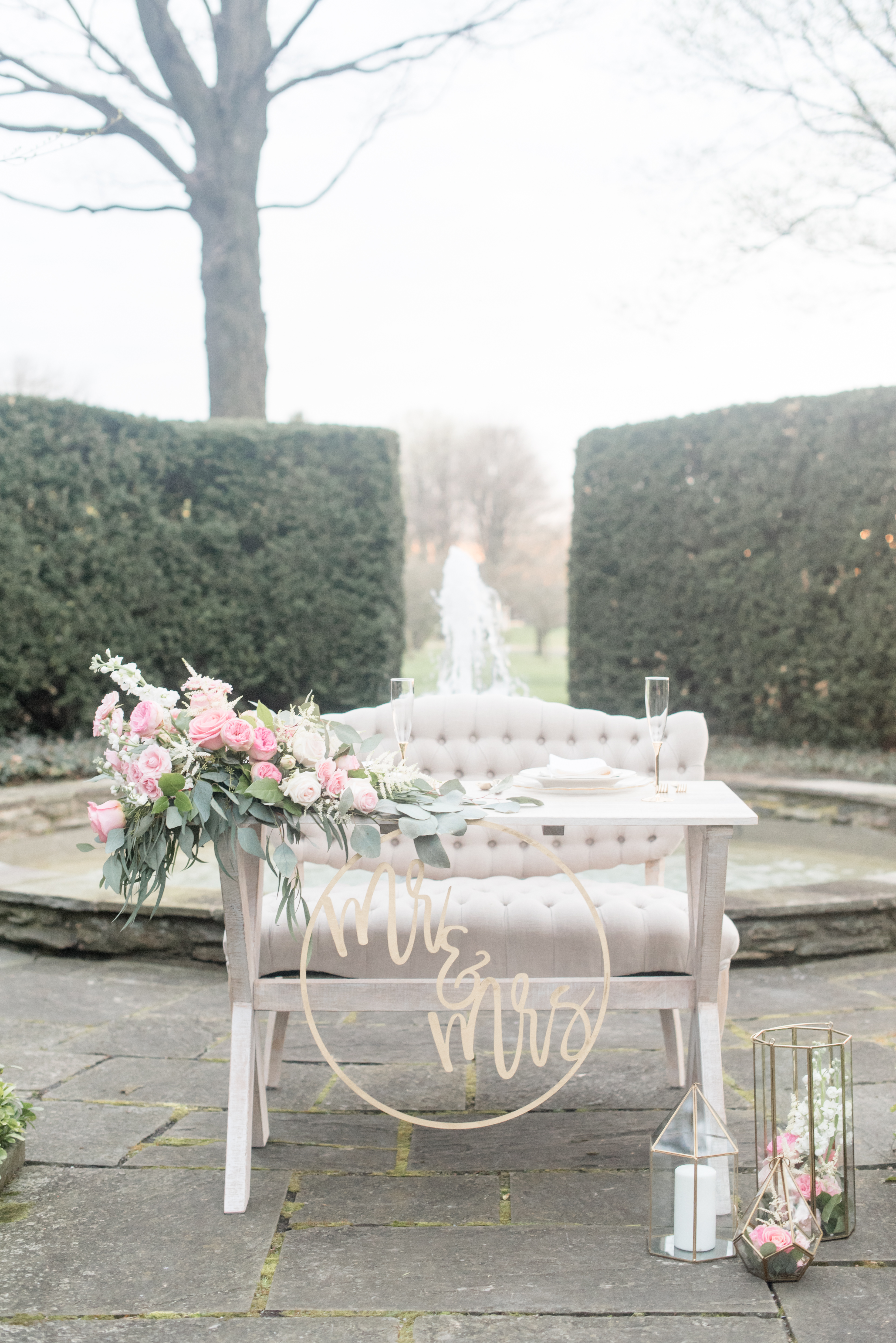 sweet heart table with florals and a huge Mr and Mrs laser cut sign in front