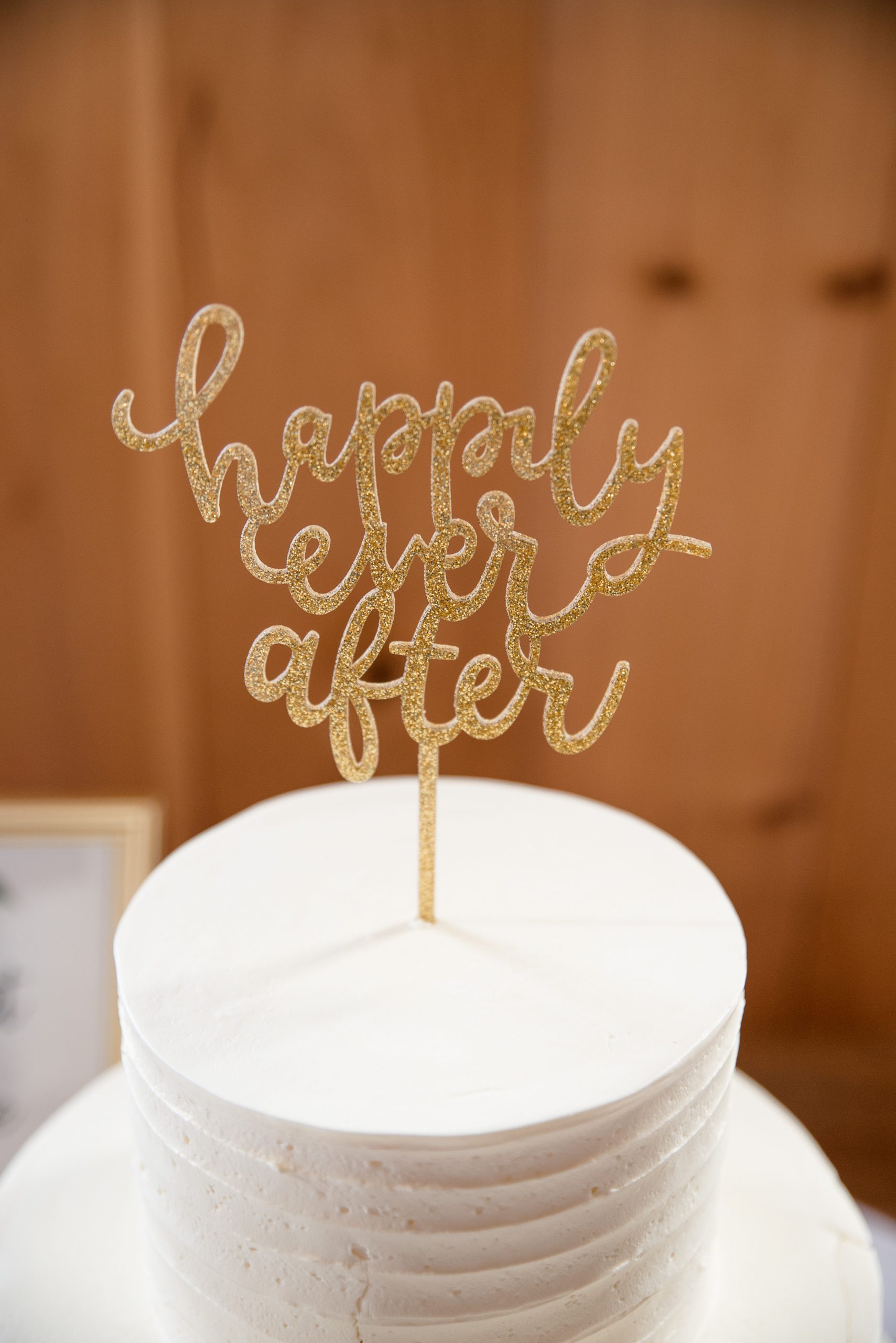 happily ever after cake topper on whie wedding cake