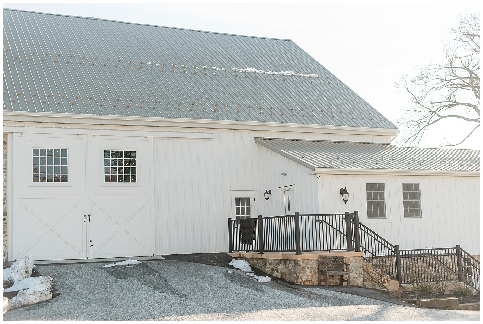exterior photo of white barn with black wrought iron staircase connected to white exterior door at The Barn at Stoneybrooke in Atglen, PA