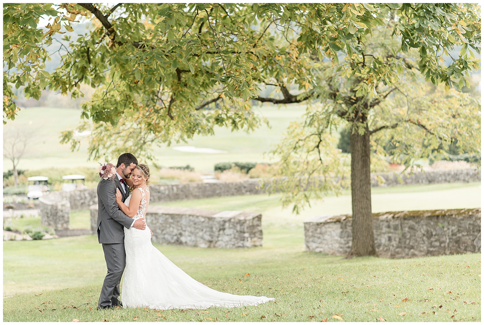 groom hugging bride in front of pond at hayfields country club in maryland