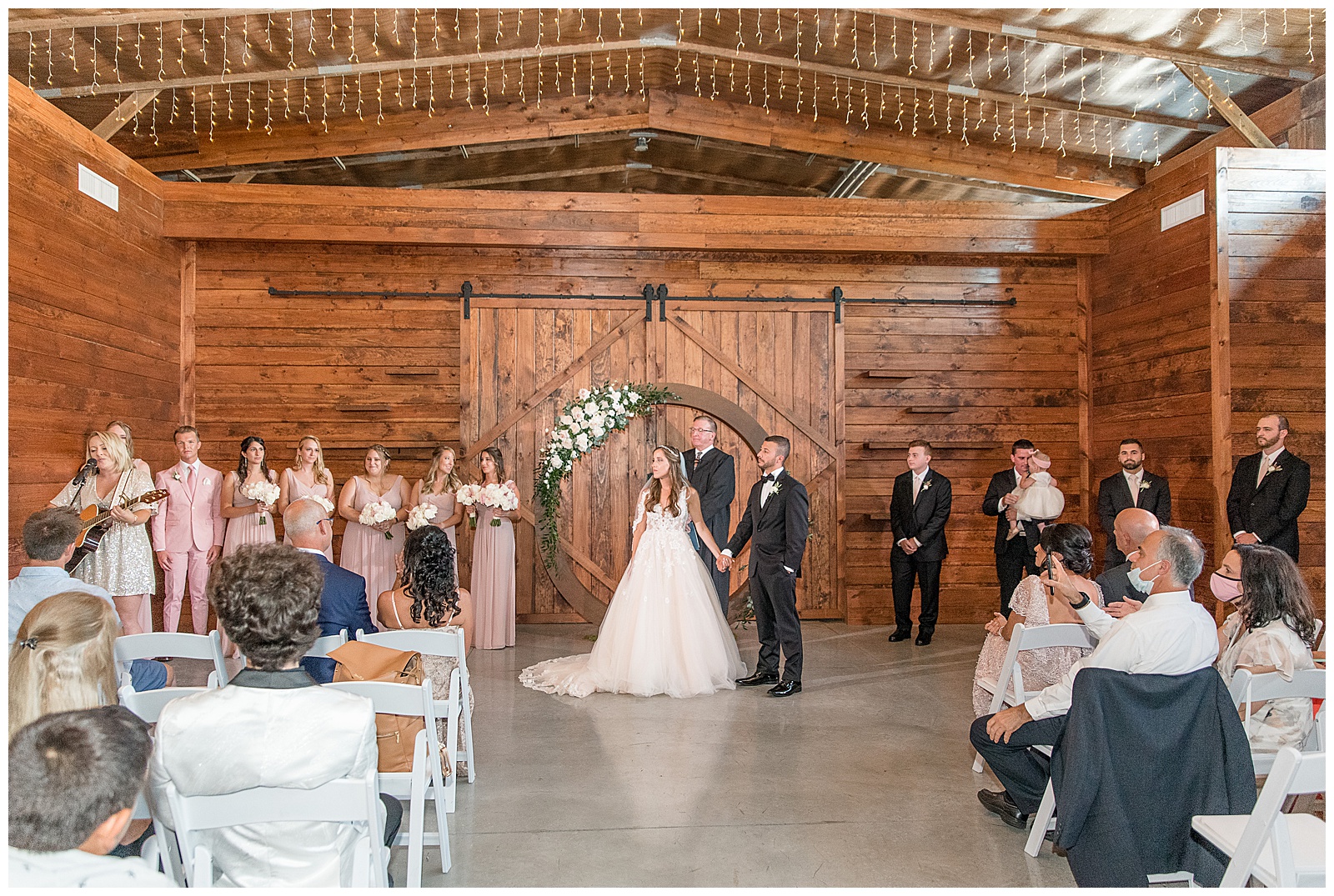 rustic barn wedding ceremony with exposed wood beams and barn door at The Barn at Silverstone