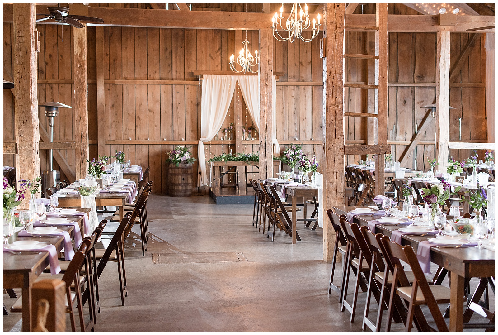 stunning rustic barn indoor reception area with exposed wooden beams and chandeliers at Stoltzfus Homestead and Gardens
