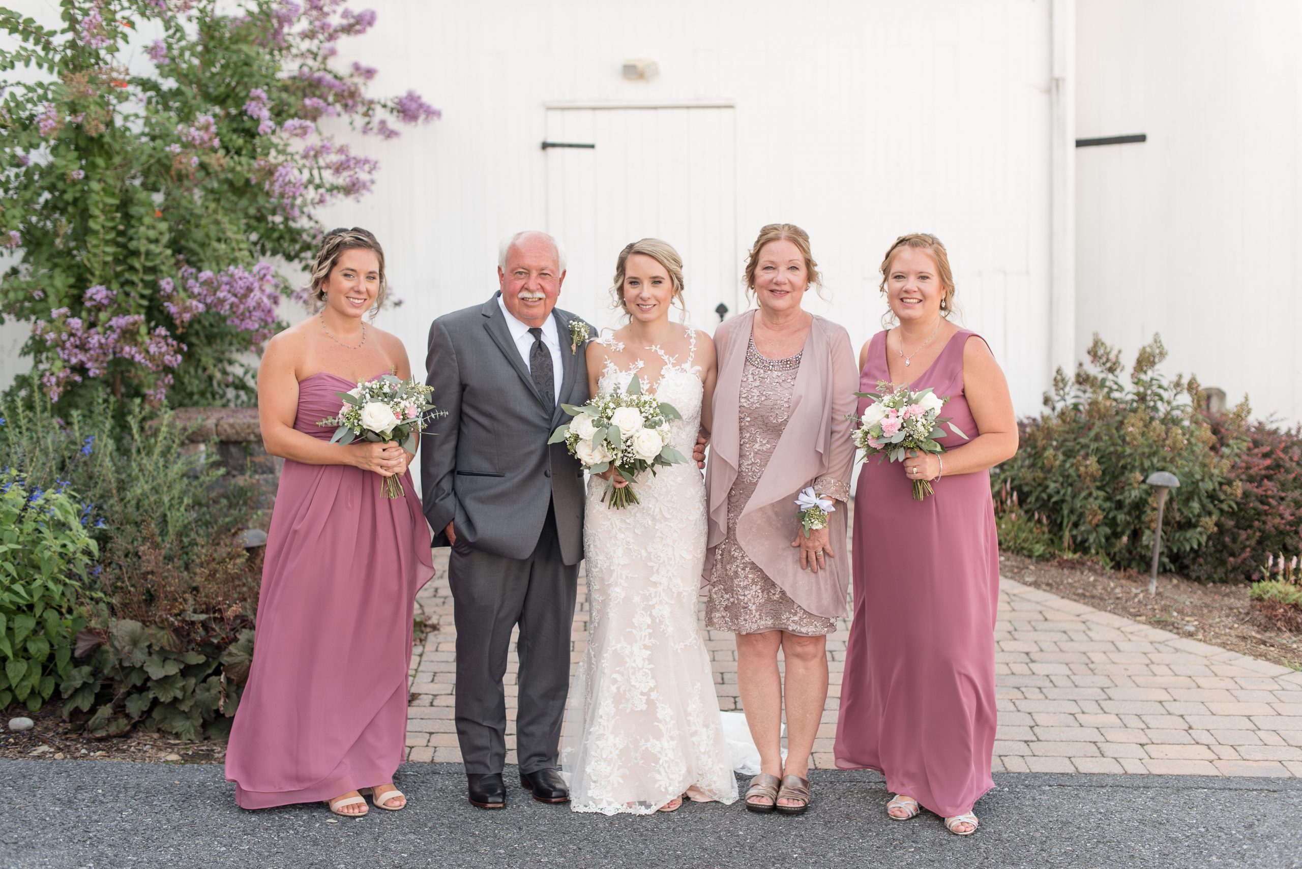 family formals in front of white barn at Lakefield Weddings