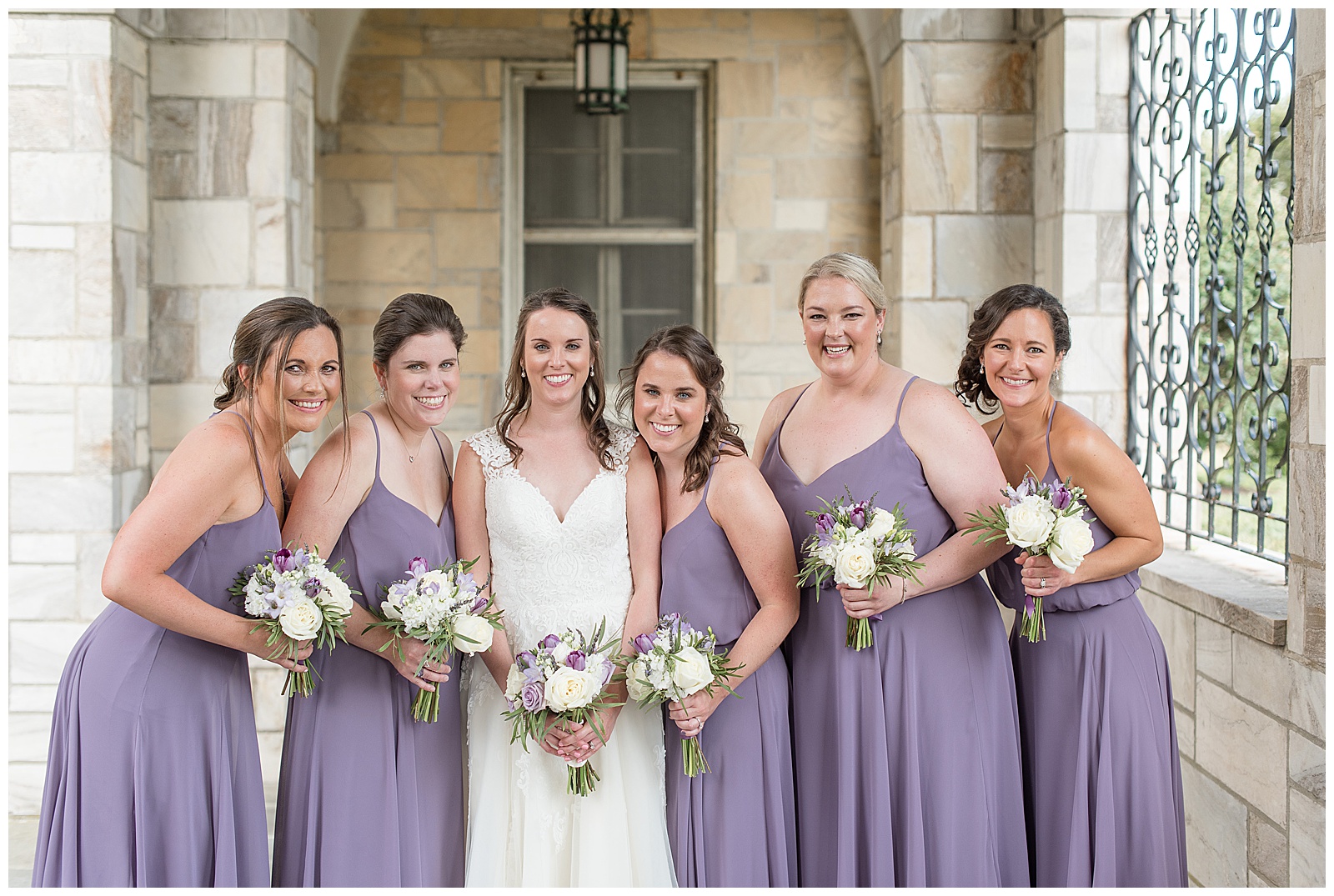 bridesmaids in light purple dresses smiling at camera